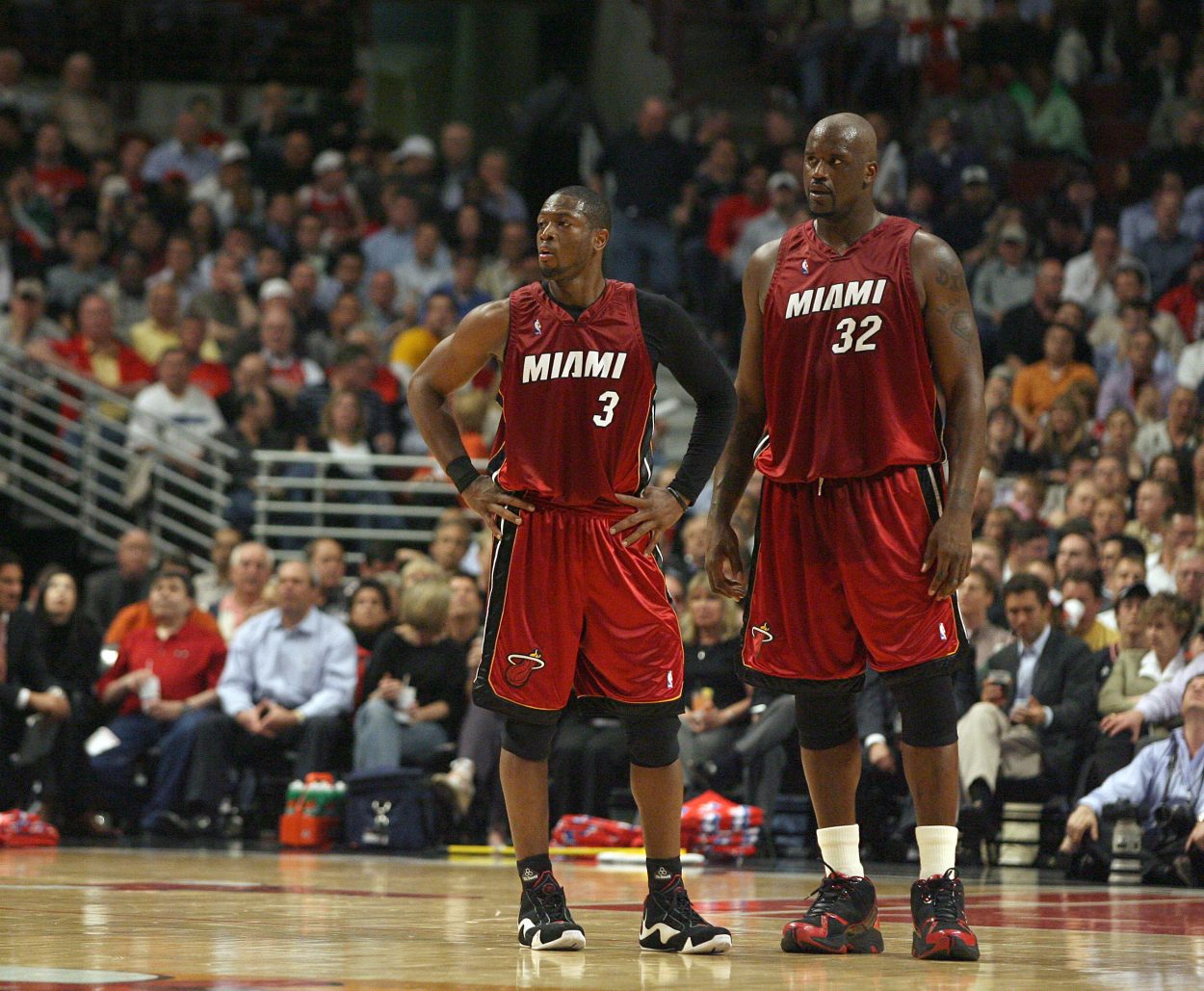 Former Miami Heat teammates Dwyane Wade and Shaquille O'Neal look on during an NBA game in 2007