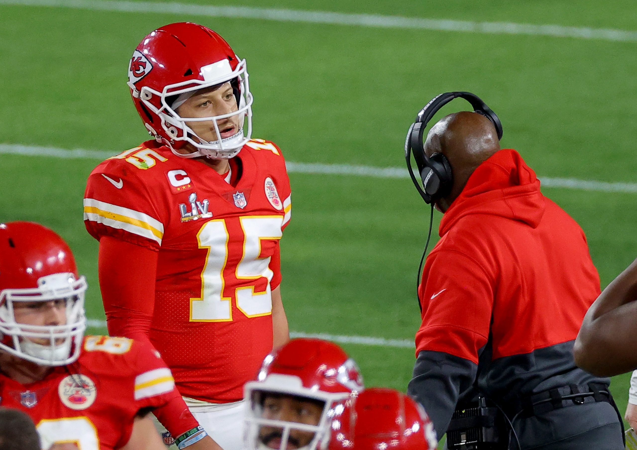 Patrick Mahomes of the Kansas City Chiefs speaks with offensive coordinator Eric Bieniemy during the fourth quarter against the Tampa Bay Buccaneers in Super Bowl LV.