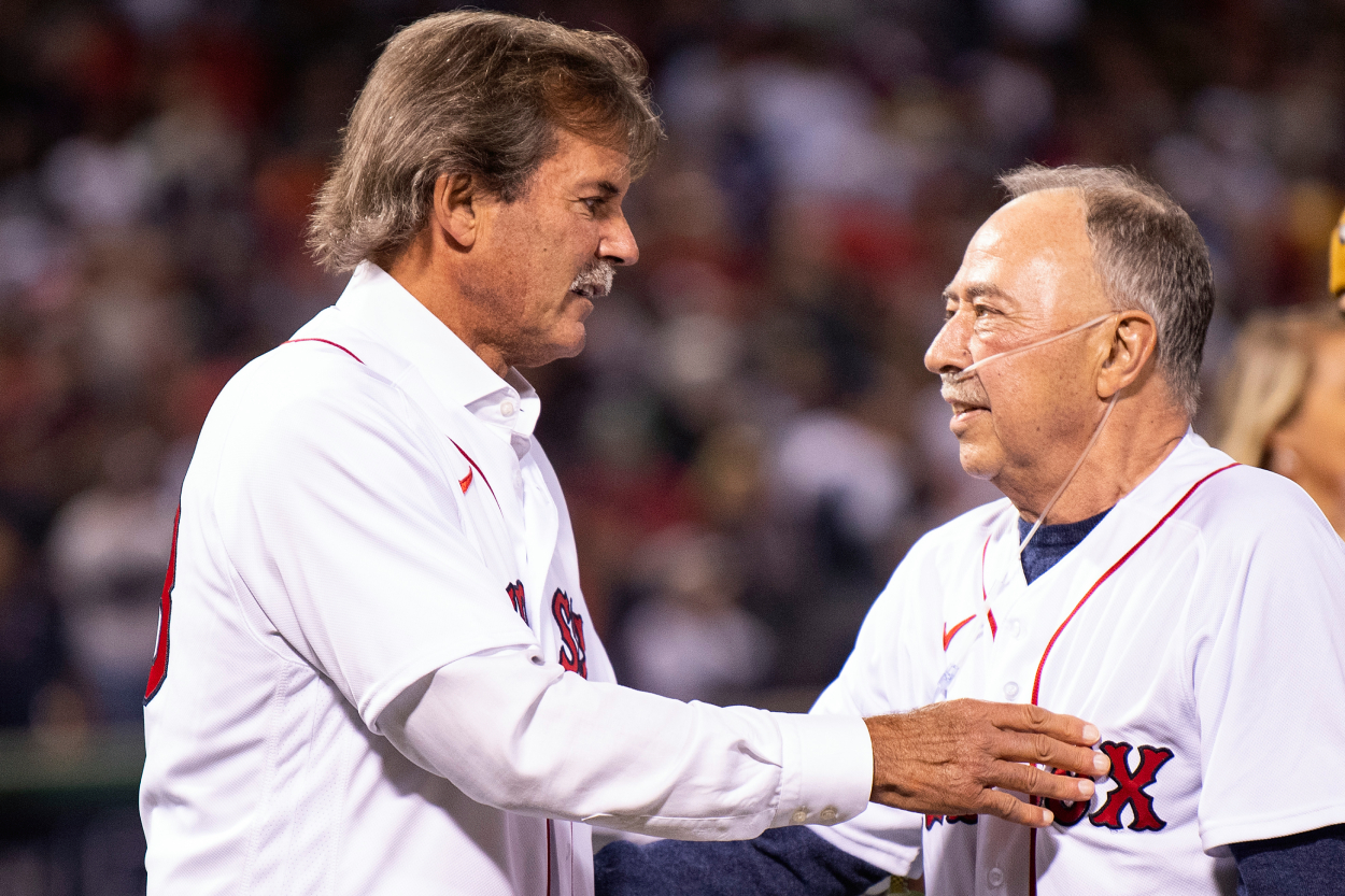 Former Boston Red Sox second baseman and NESN broadcaster Jerry Remy is greeted by former pitcher and NESN broadcaster Dennis Eckersley after throwing out a ceremonial first pitch.