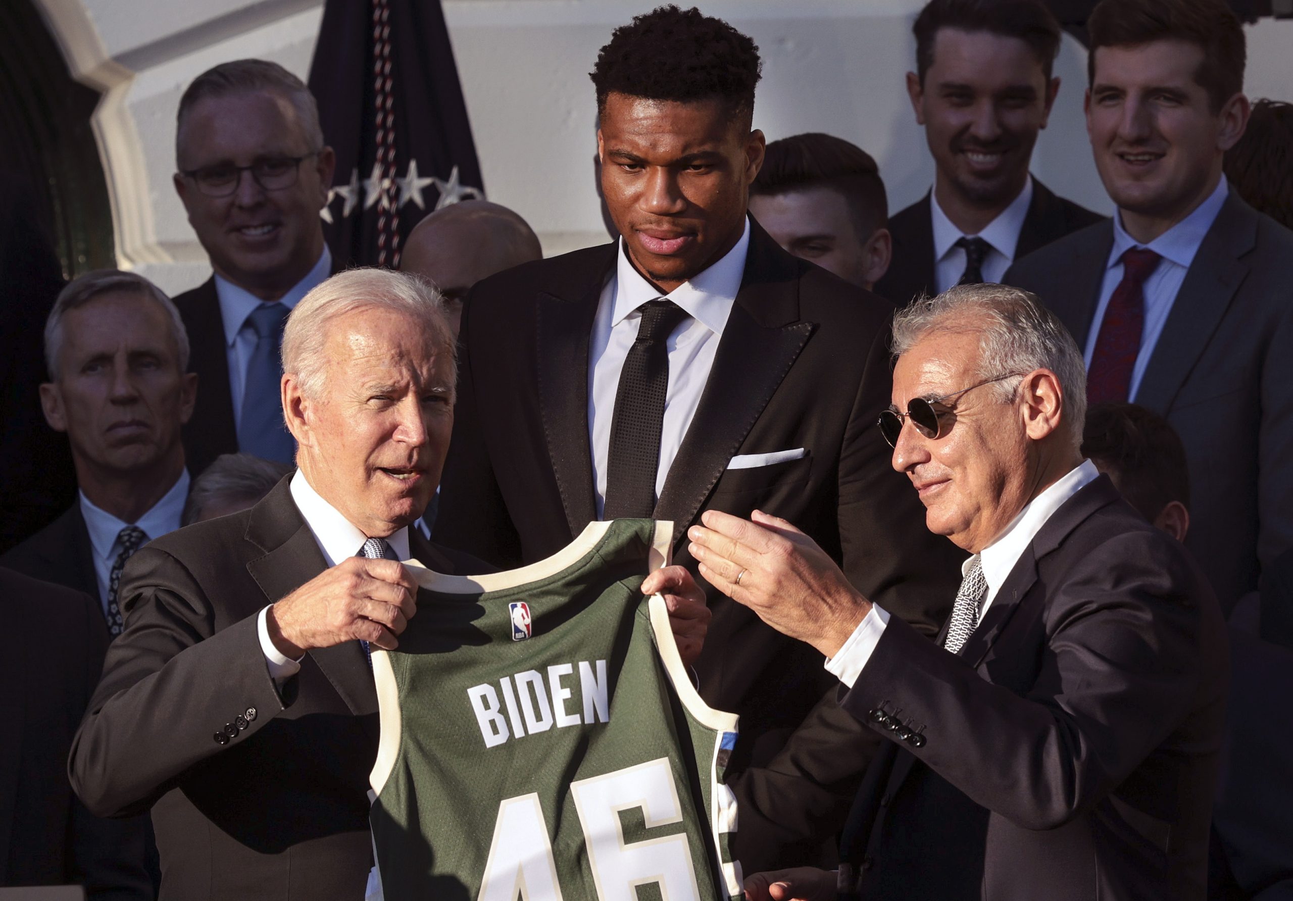 U.S. President Joe Biden receives a jersey from Milwaukee Bucks owner Marc Lasry (R) as Giannis Antetokounmpo watches.