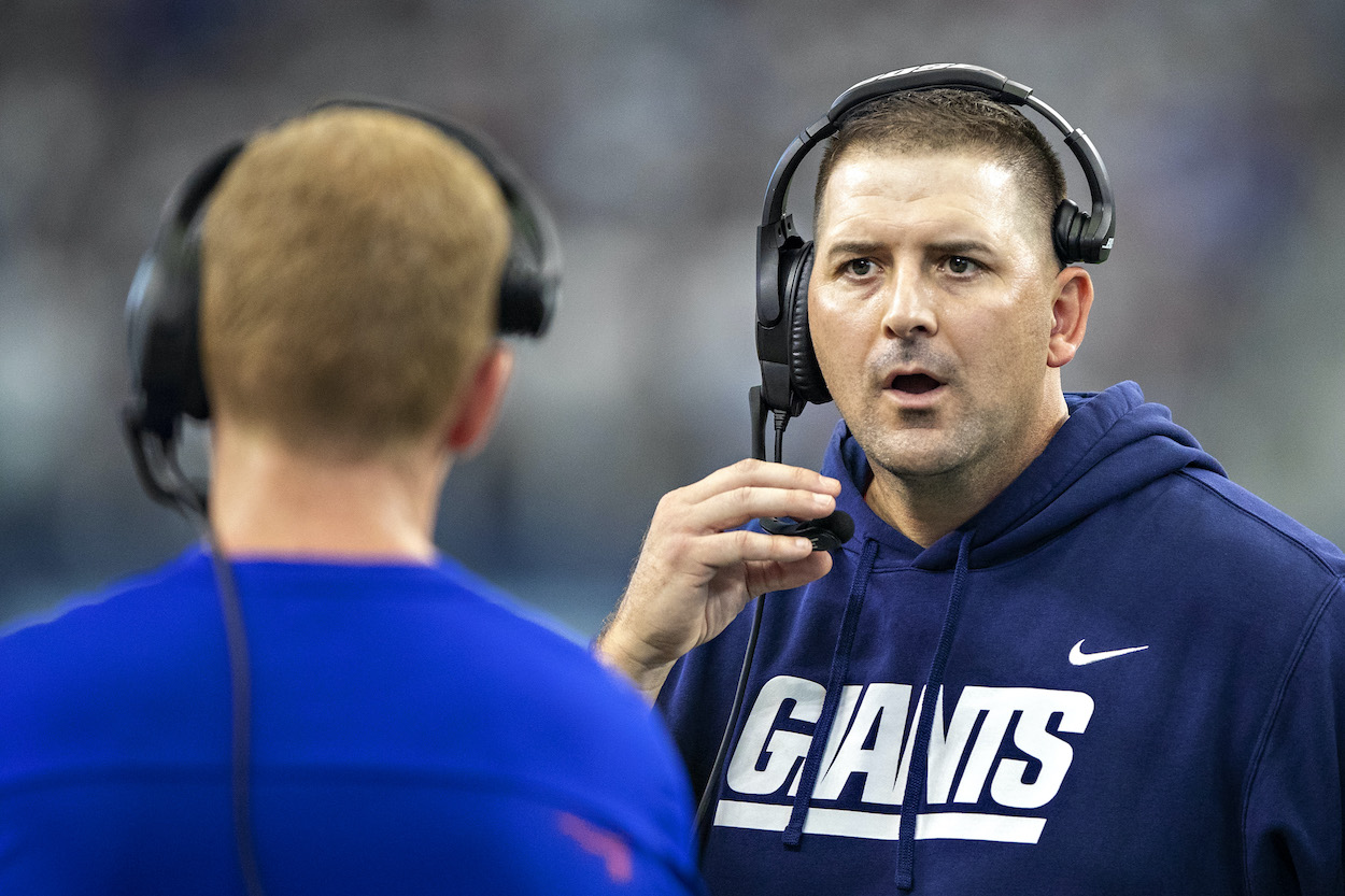 Head Coach Joe Judge talks with offensive coordinator Jason Garrett of the New York Giants during a game against the Dallas Cowboys at AT&T Stadium on October 10, 2021 in Arlington, Texas. The Cowboys defeated the Giants 44-20.