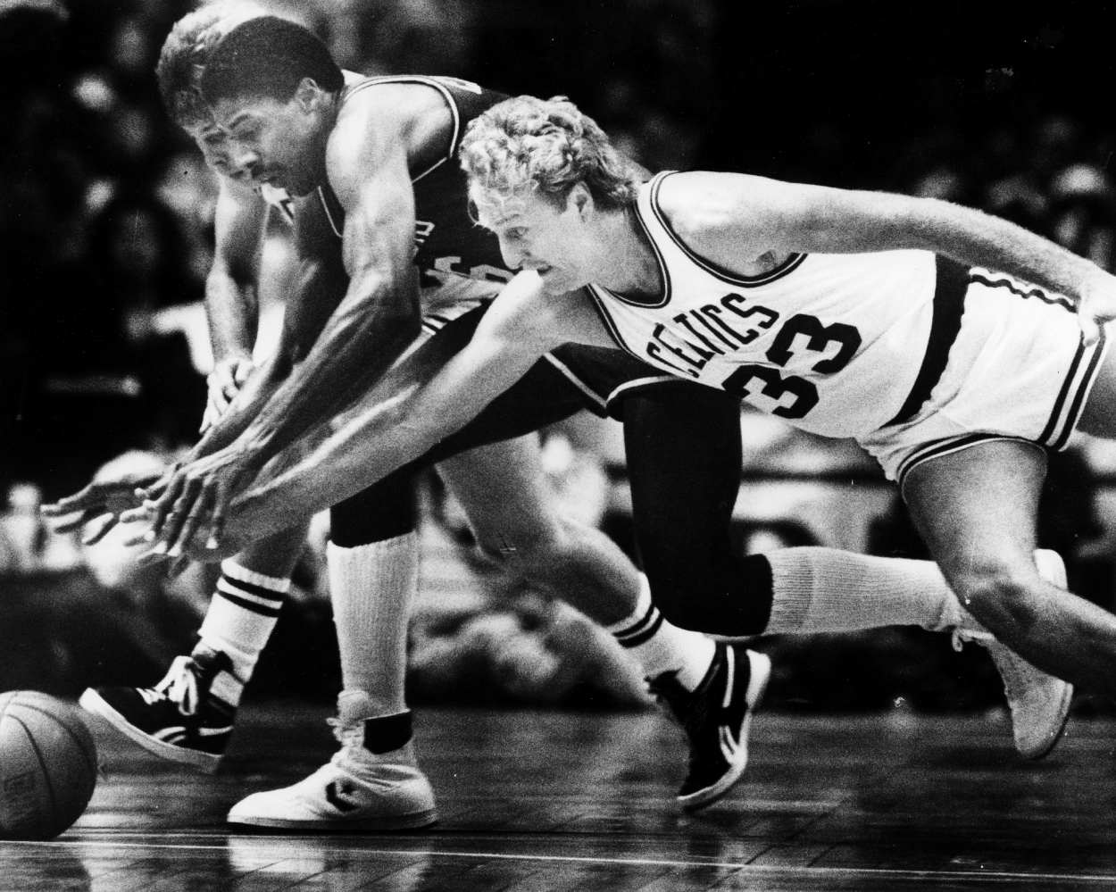 Left to right, Celtics player Danny Ainge, the Sixers' Julius Irving and the Celtics' Larry Bird dive for a loose ball.