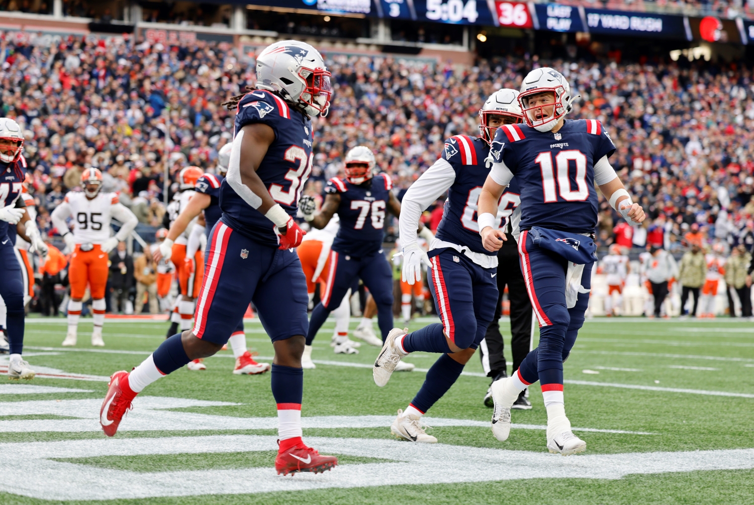 New England Patriots rookie running back Rhamondre Stevenson celebrates scoring a touchdown with Mac Jones and his teammates.