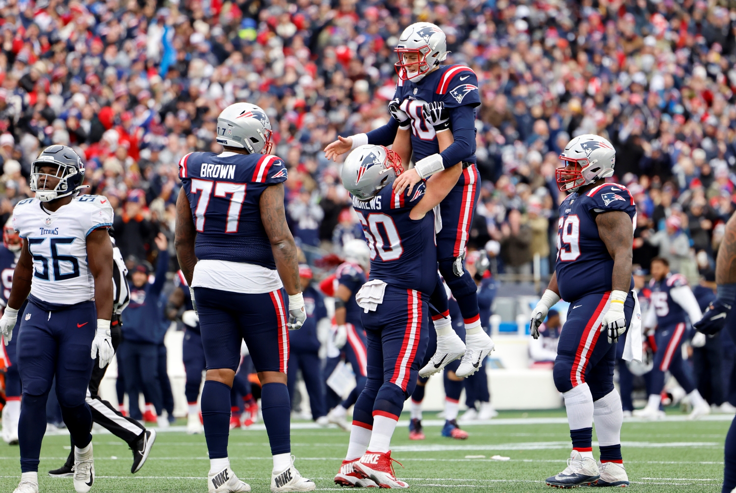 New England Patriots center David Andrew lifts quarterback Mac Jones in the air after a touchdown pass.