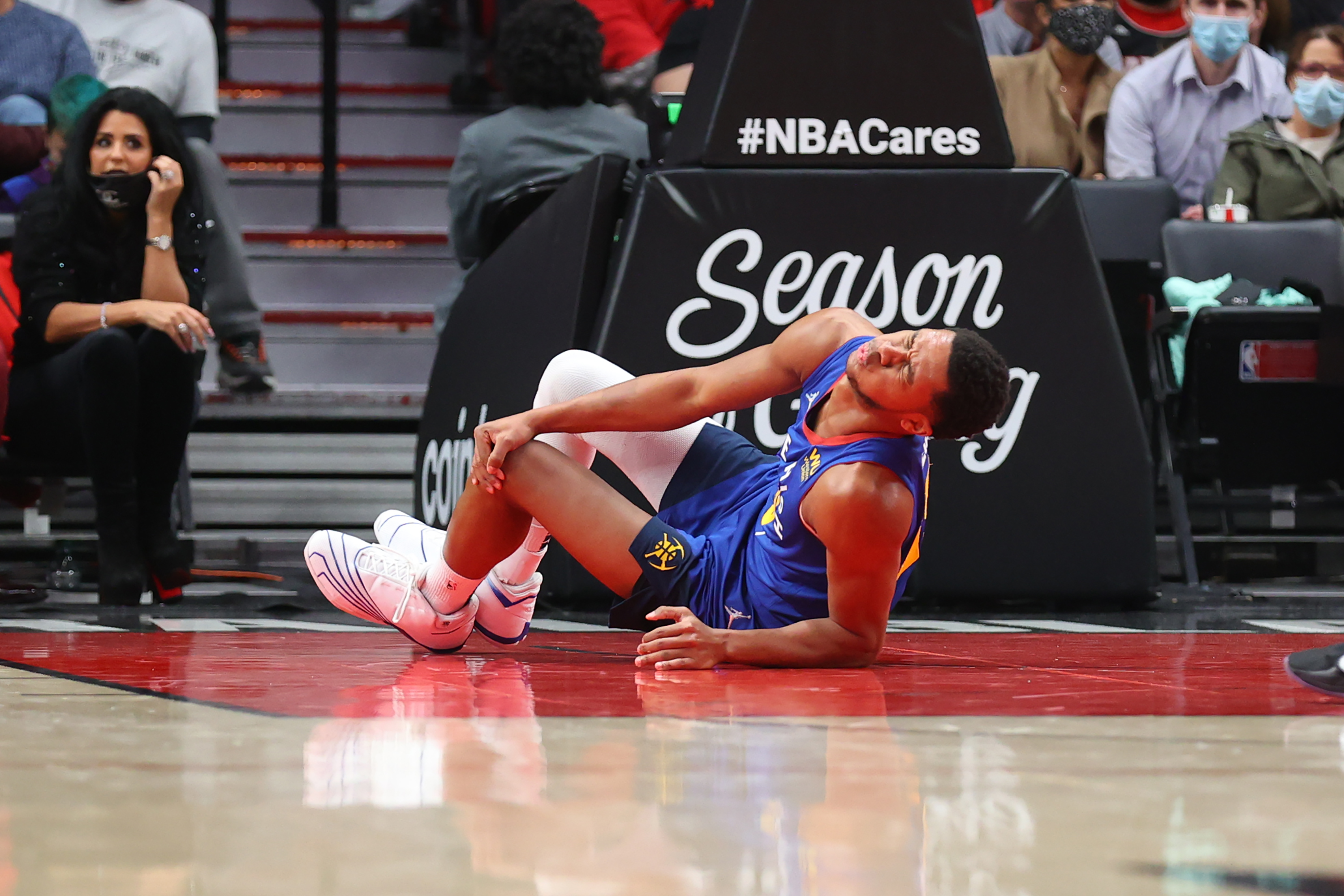 Denver Nuggets guard P.J. Dozier grabs his knee during a game against the Portland Trail Blazers