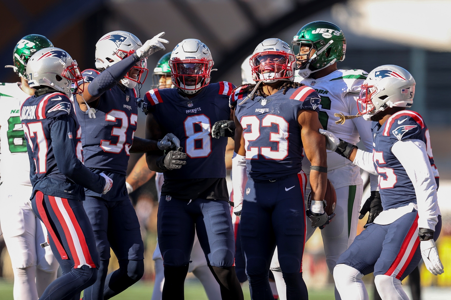 New England Patriots defenders celebrate recording a turnover against the New York Jets.