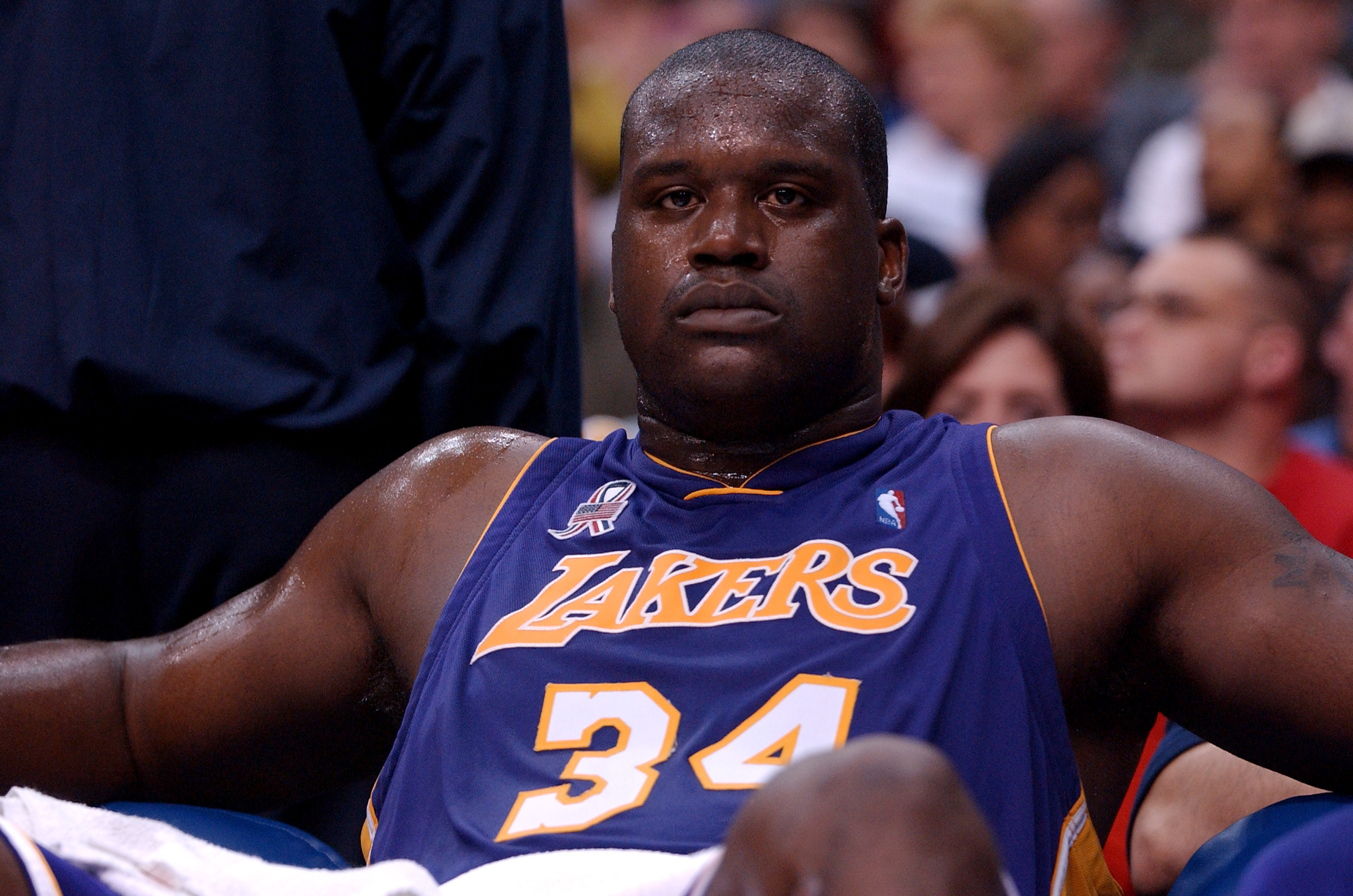 Former Los Angeles Lakers center Shaquille O'Neal looks on from the bench during an NBA game in April 2002