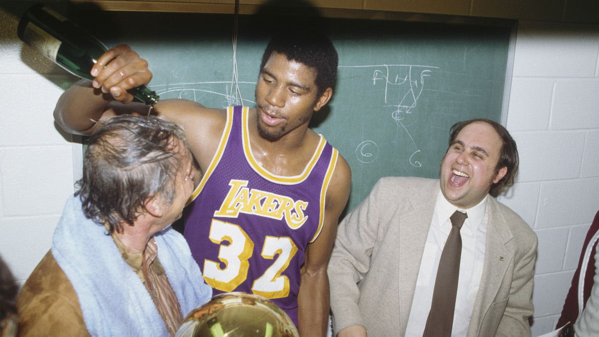 Magic Johnson and Dr. Jerry Buss celebrate the first of their five championships with the Los Angeles Lakers