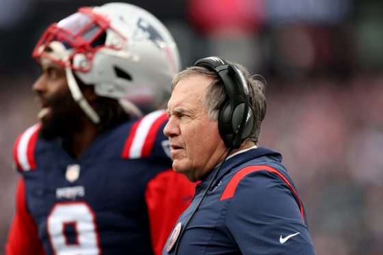 Patriots coach Bill Belichick watches a game alongside Matthew Judon.