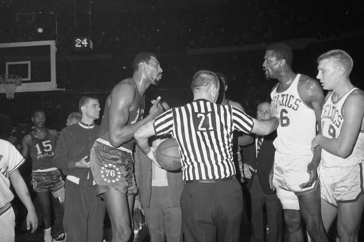 Bill Russell of the Celtics turns a deaf ear on Wilt Chamberlain .