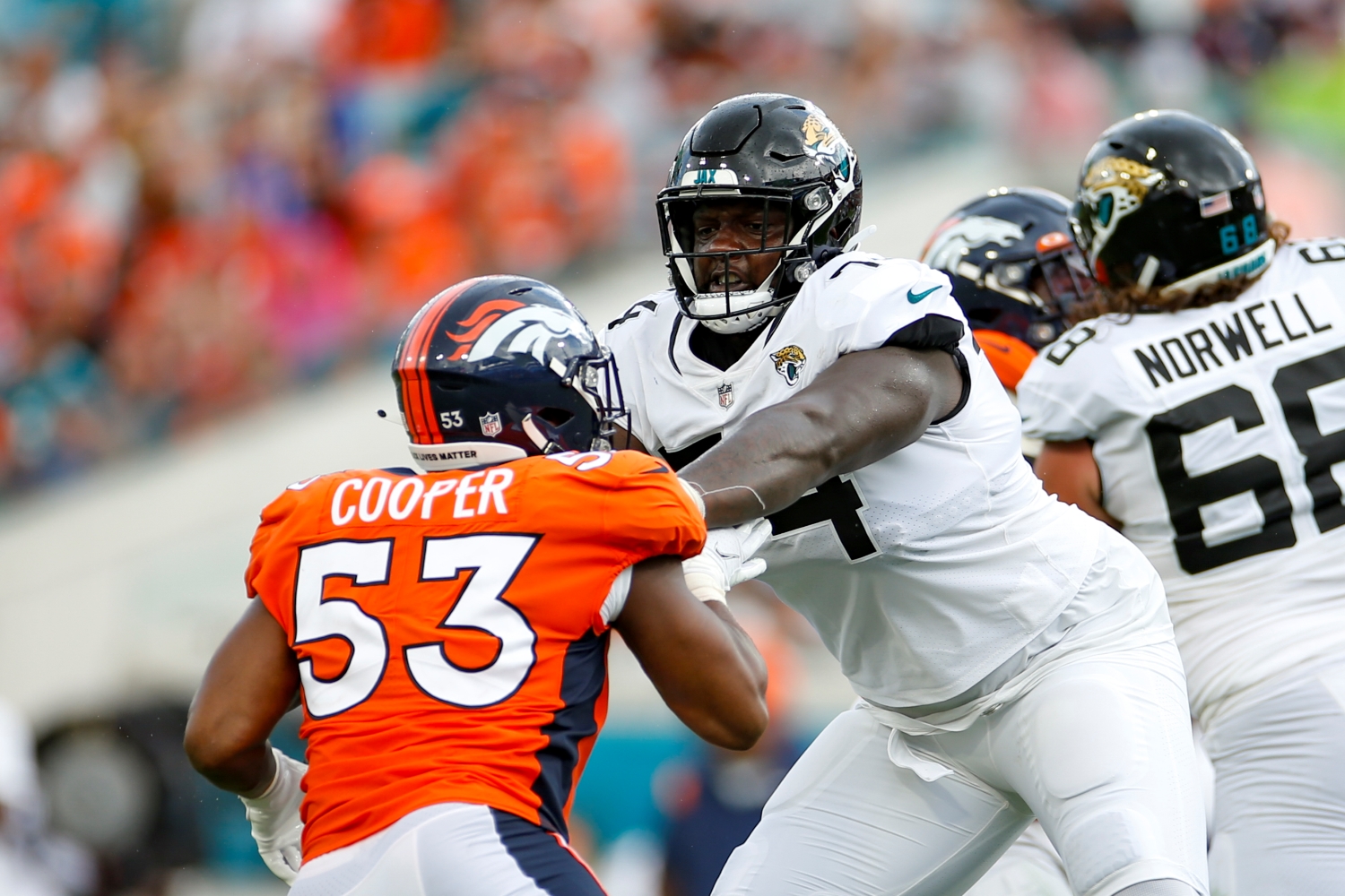 Jaguars LT Cam Robinson blocks a Denver Broncos defender.