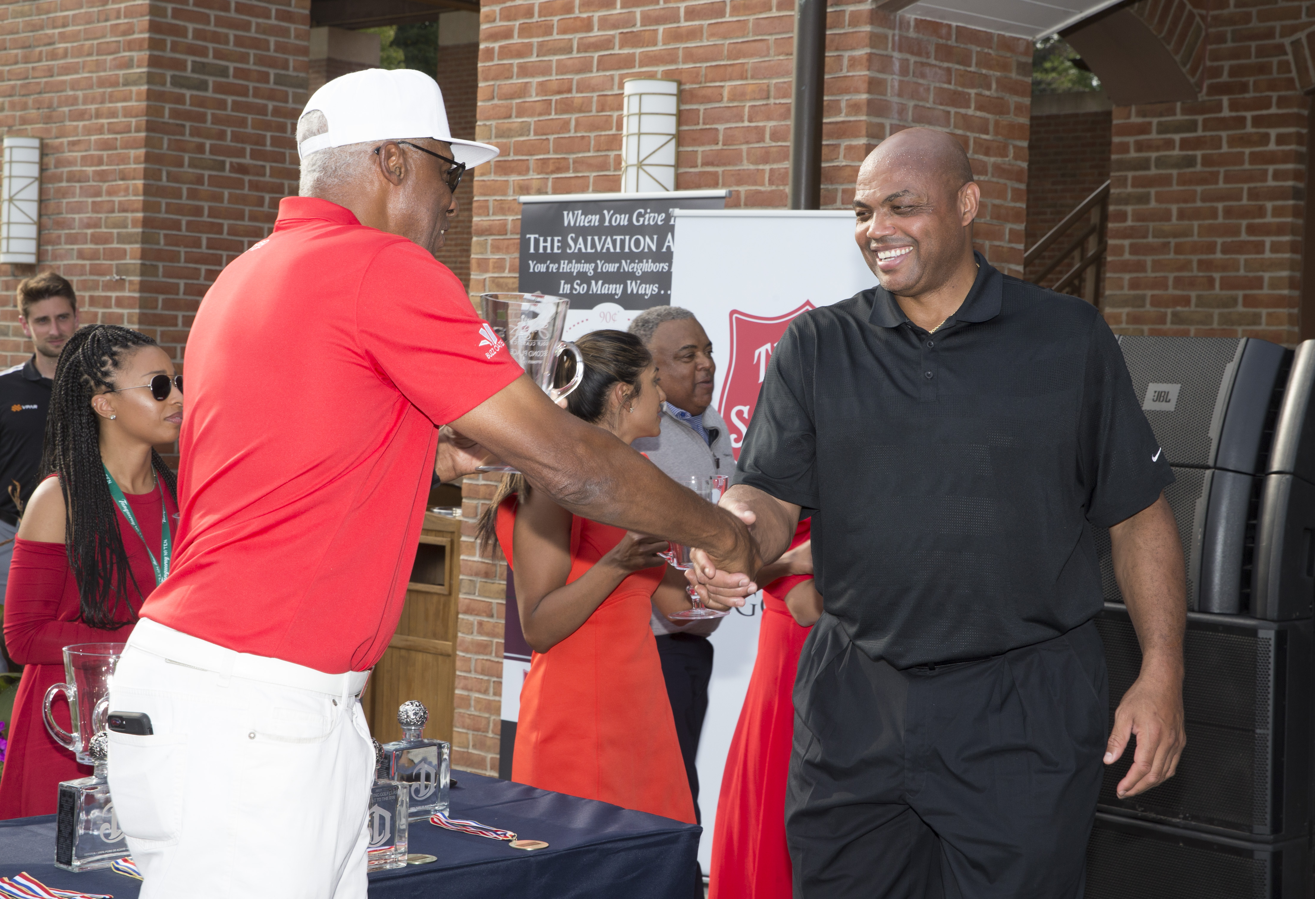 Former Philadelphia 76ers teammates Charles Barkley and Julius Erving shake hands before a 2017 golf outing.