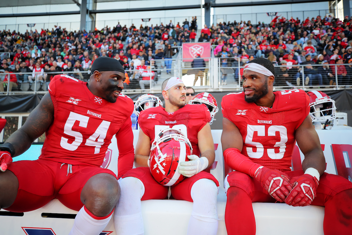 Jonathan Massaquoi, A.J. Tarpley, and Jameer Thurman of the DC Defenders talk during a 2020 XFL game