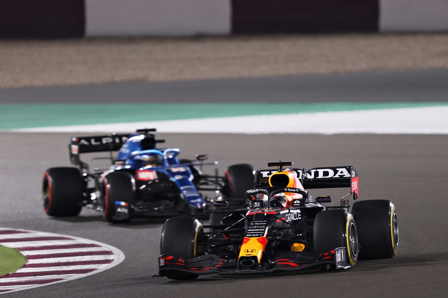 Max Verstappen, driving the Red Bull Racing RB16B Honda, leads Fernando Alonso, driving the Alpine A521 Renault, during the Formula 1 Grand Prix of Qatar on Nov. 21, 2021.