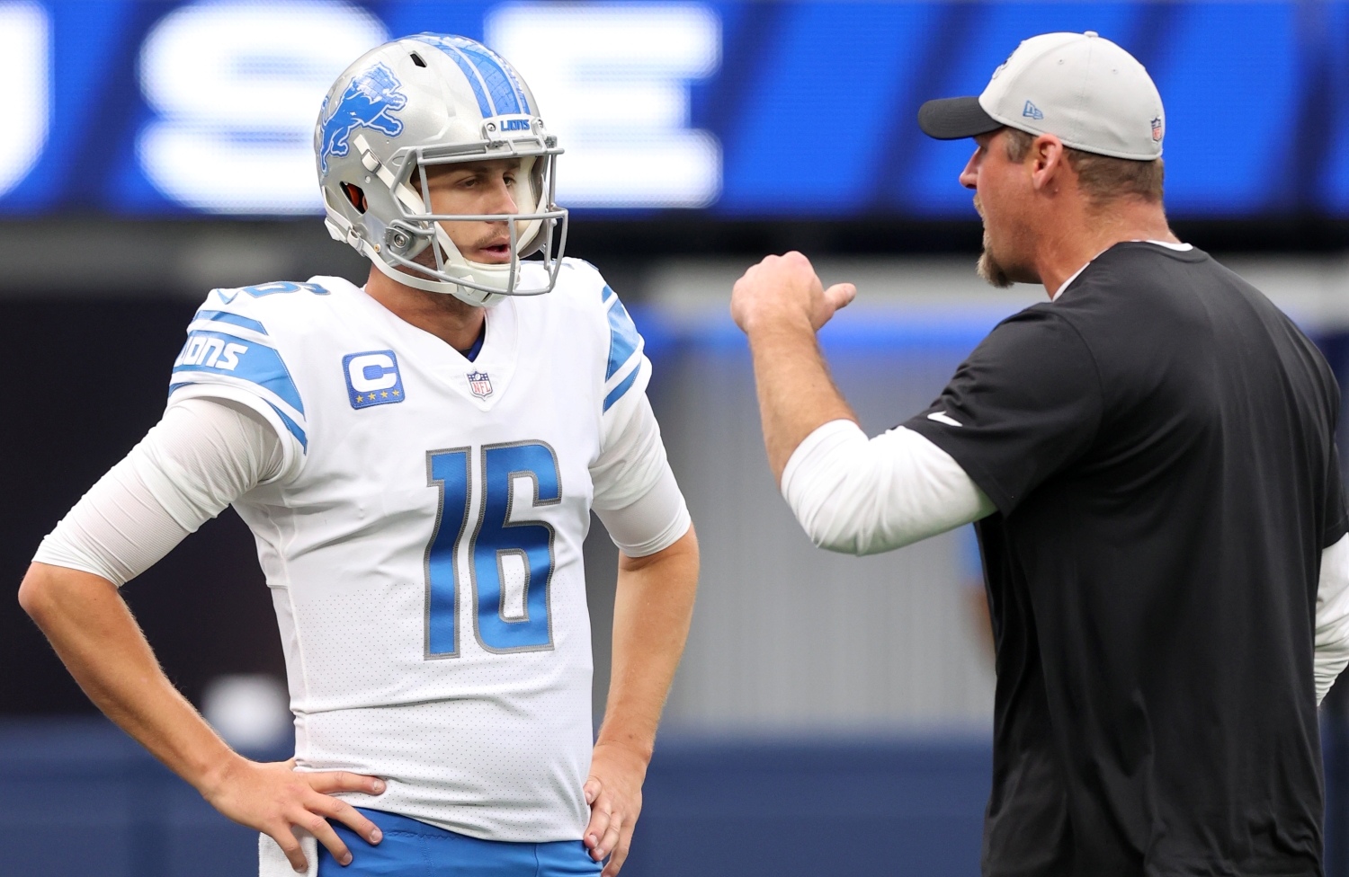 Detroit Lions coach Dan Campbell speaks to quarterback Jared Goff before a game.