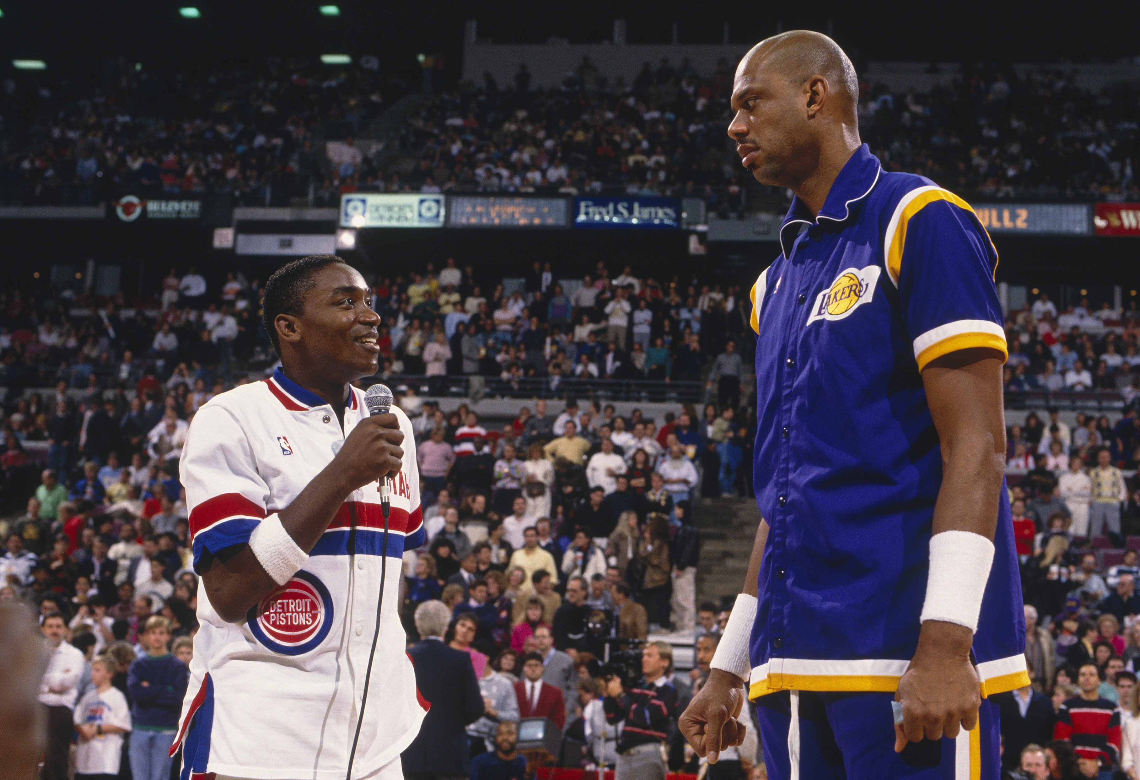 Detroit Pistons great Isiah Thomas speaks to Los Angeles Lakers icon Kareem Abdul-Jabbar during Cap's retirement ceremony in 1989