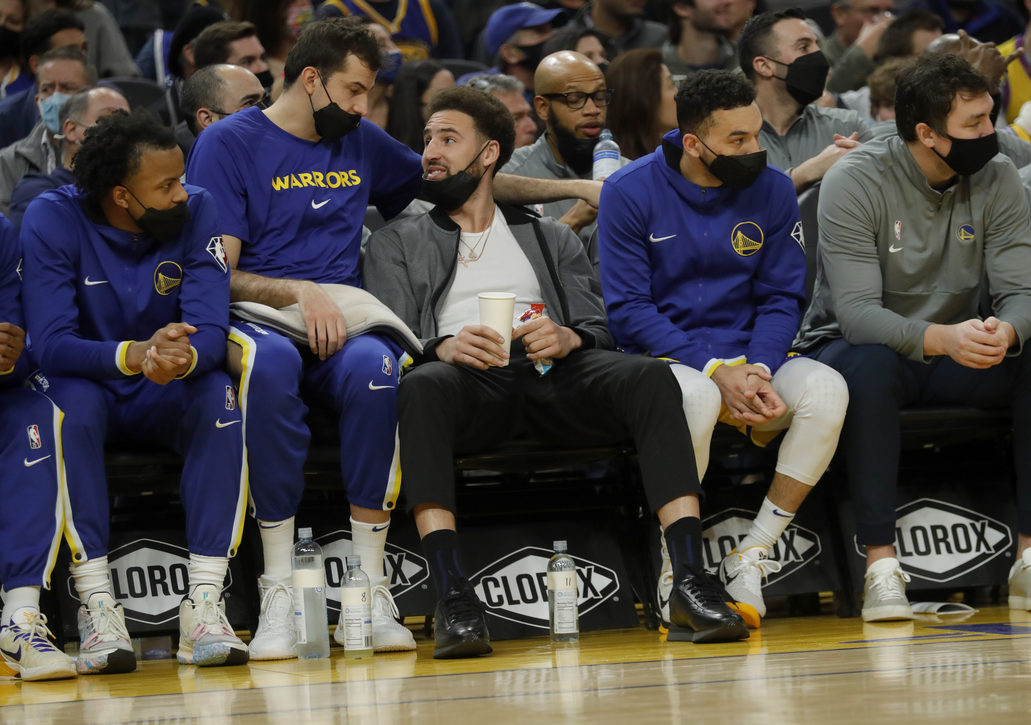 Golden State Warriors star Klay Thompson (middle) on the bench with teammates during an NBA game against the Sacramento Kings