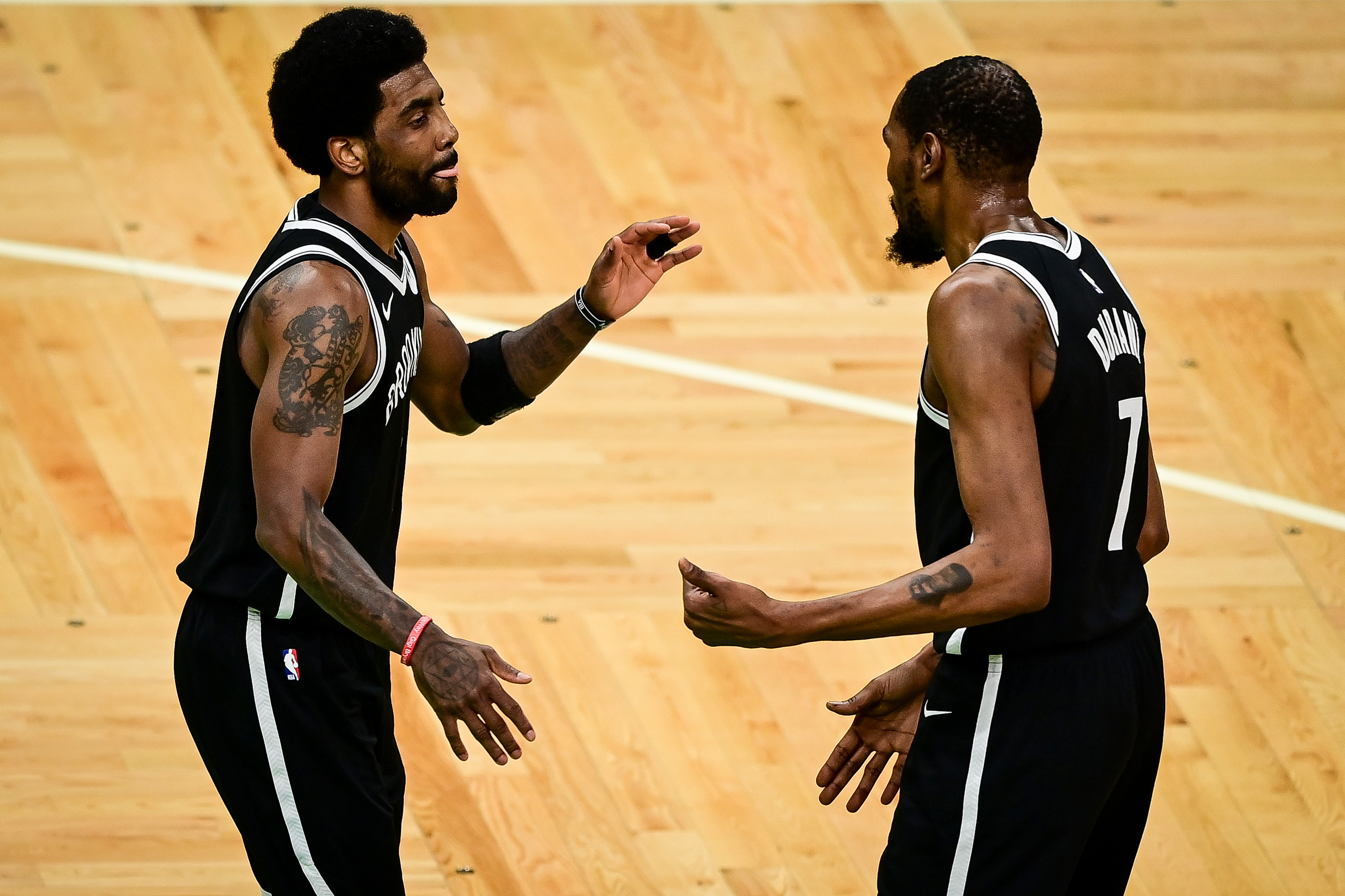 Brooklyn Nets stars Kyrie Irving and Kevin Durant celebrate during a game against the Boston Celtics in the 2021 NBA Playoffs