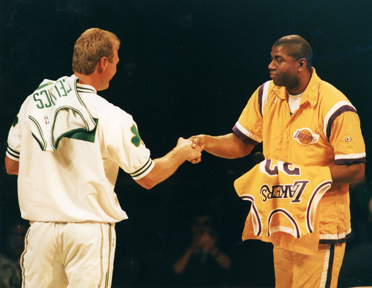 Celtics forward Larry Bird and Lakers guard Magic Johnson embrace each other.