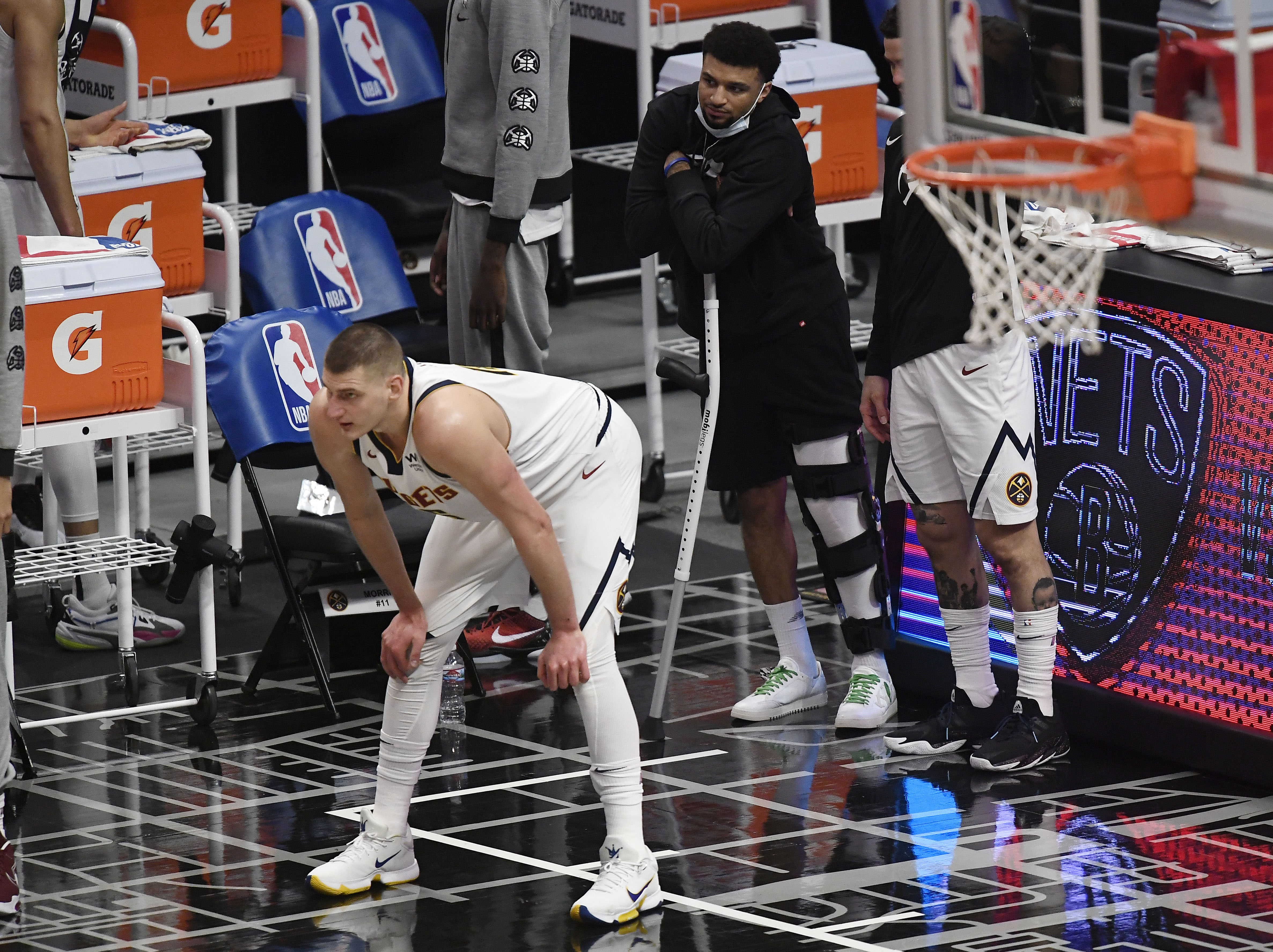 Denver Nuggets stars Nikola Jokic and Jamal Murray look on during an NBA game against the LA Clippers in May 2021