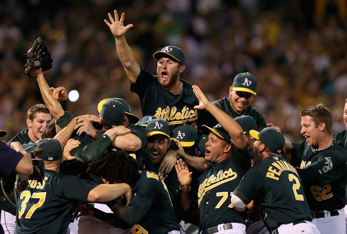 Athletics celebrate after beating the Texas Rangers to clinch a playoff spot