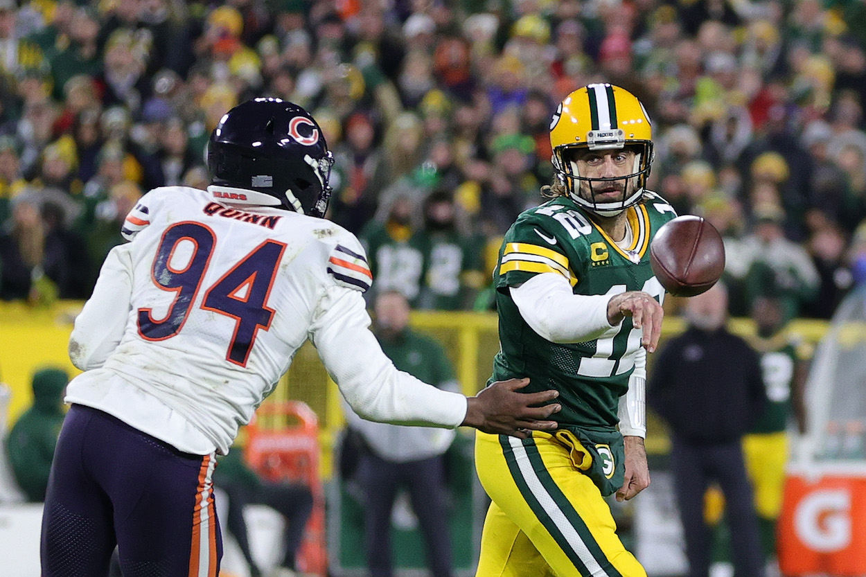 Aaron Rodgers of the Green Bay Packers is pursued by Robert Quinn of the Chicago Bears during a game at Lambeau Field on December 12, 2021 in Green Bay, Wisconsin. The Packers defeated the Bears 45-30.