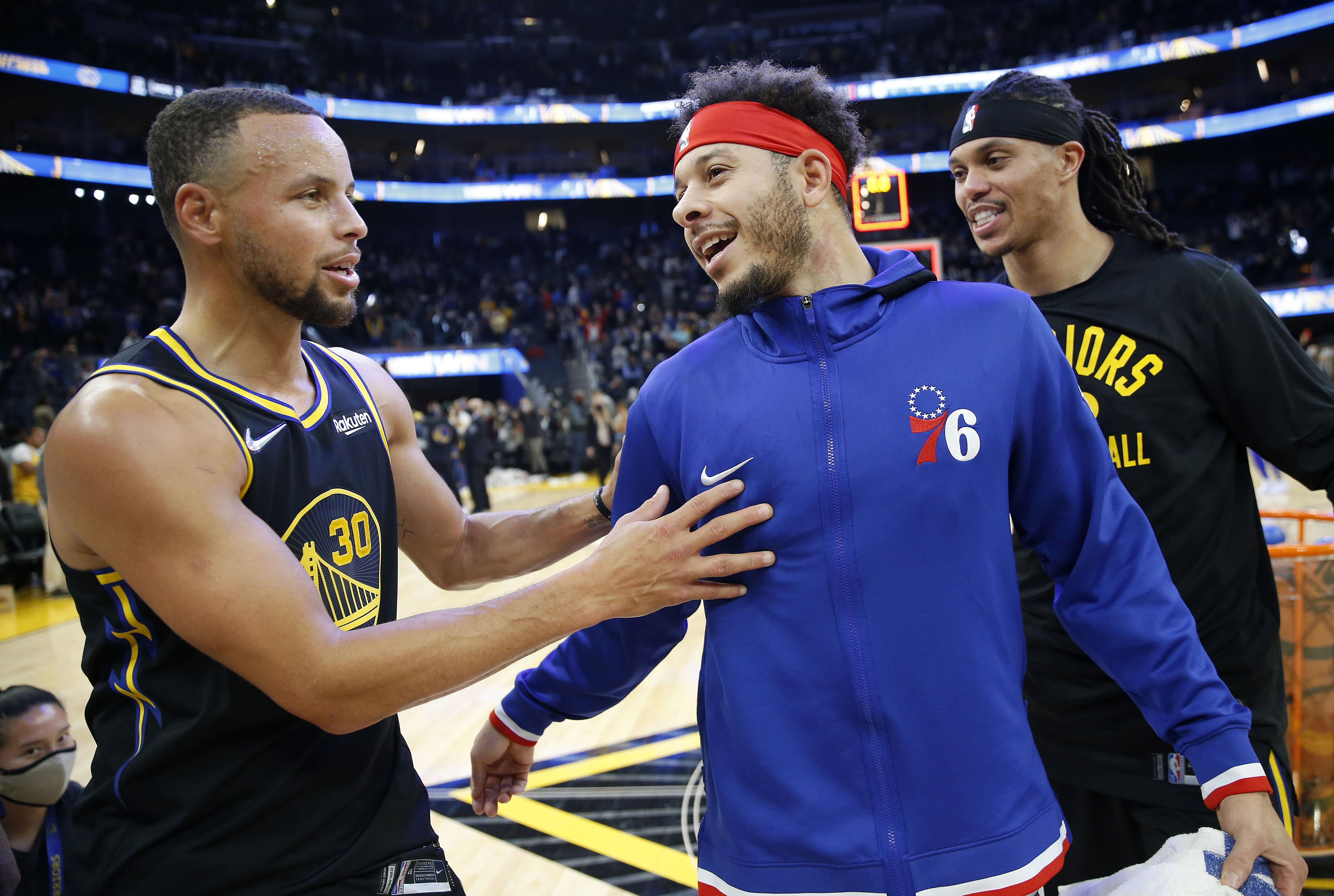 Golden State Warriors star Stephen Curry speaks with his brother and Philadelphia 76ers guard Seth Curry during a game in November 2021
