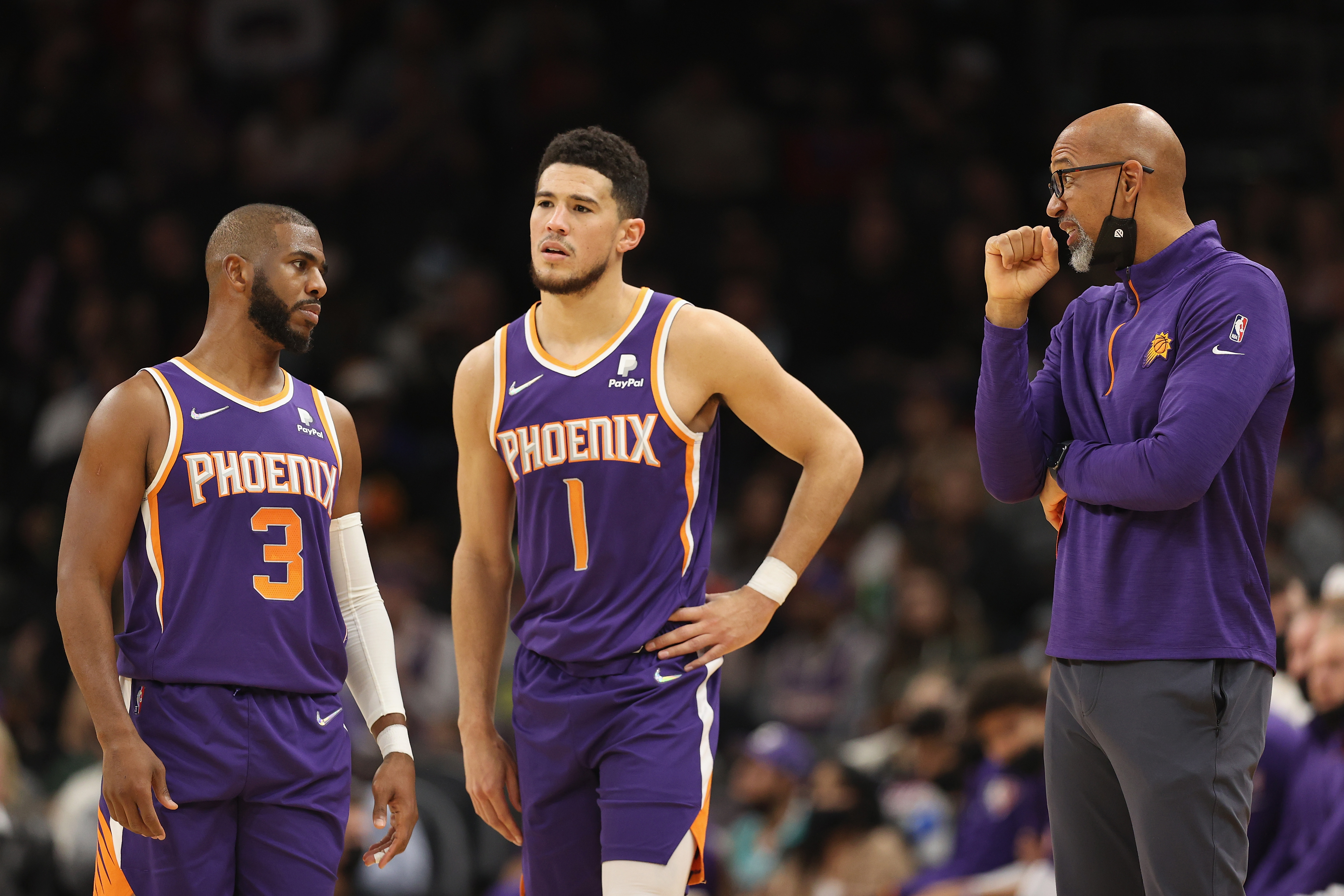 L-R: Chris Paul, Devin Booker, and Monty Williams of the Phoenix Suns talk during a game against the Charlotte Hornets