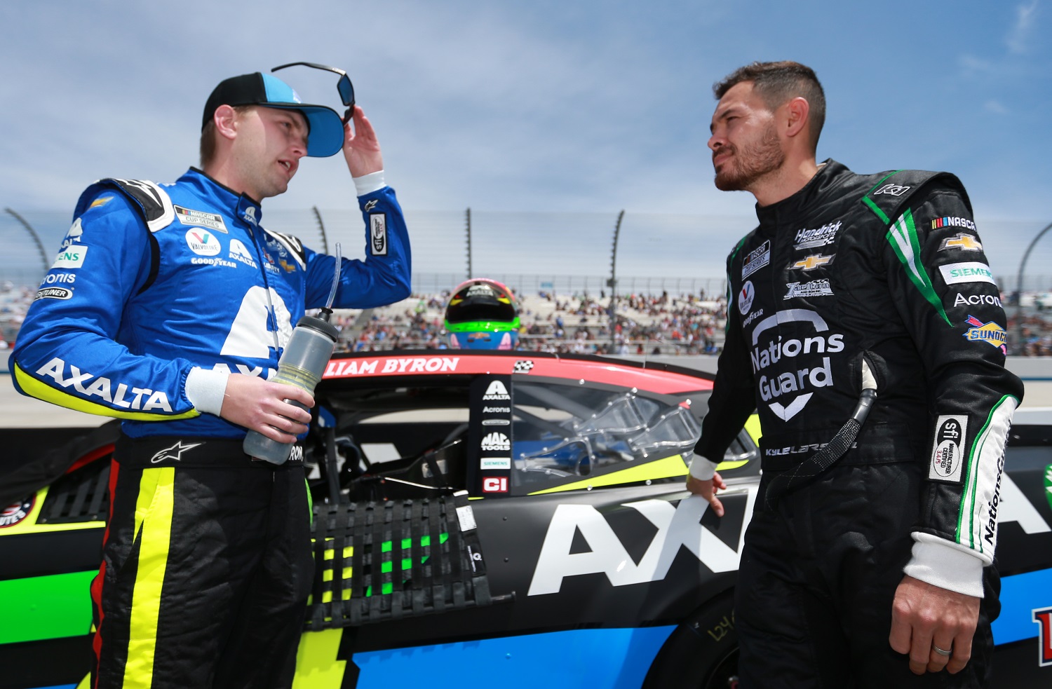 Hendrick Motorsports teammates William Byron and Kyle Larson talk on the grid at the NASCAR Cup Series Drydene 400 at Dover International Speedway on May 16, 2021.