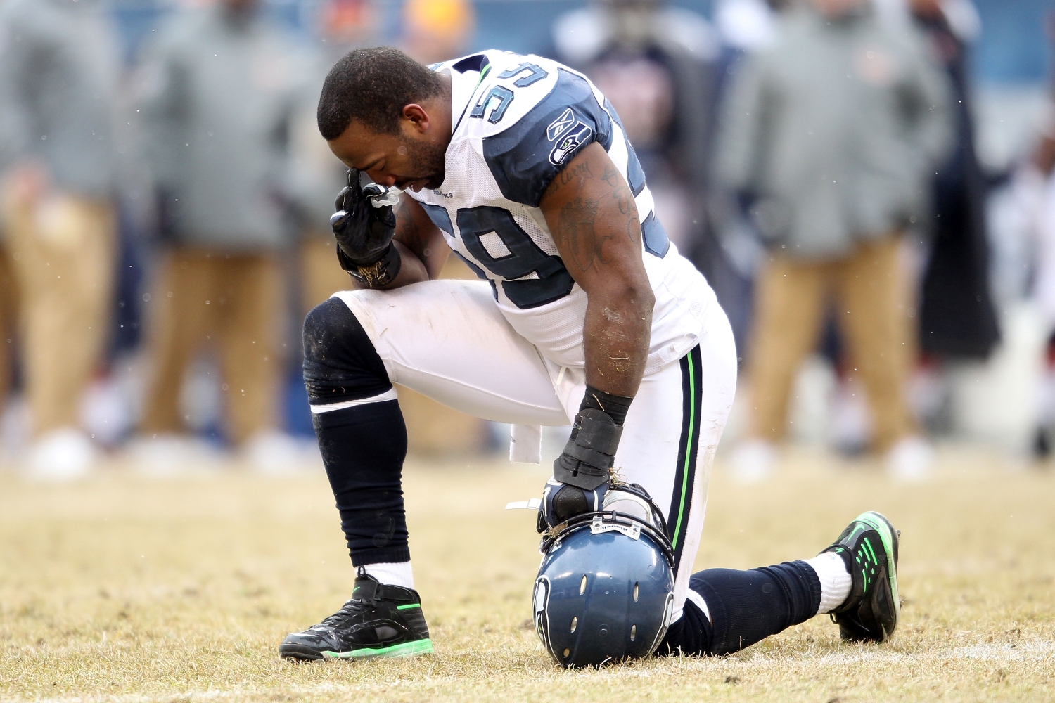 Seattle Seahawks LB Aaron Curry kneels in prayer during a game.