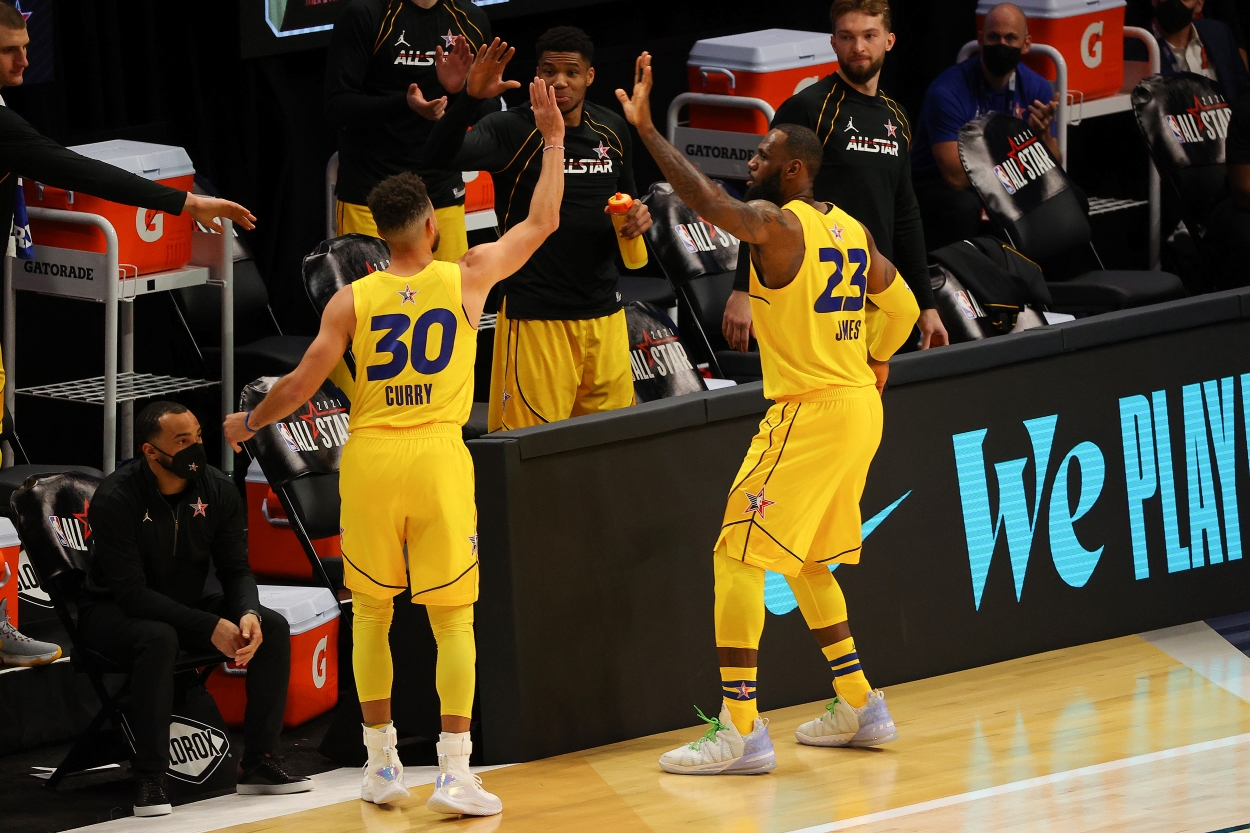 The Golden State Warriors Stephen Curry and Los Angeles Lakers LeBron James high-five during an All-Star game.