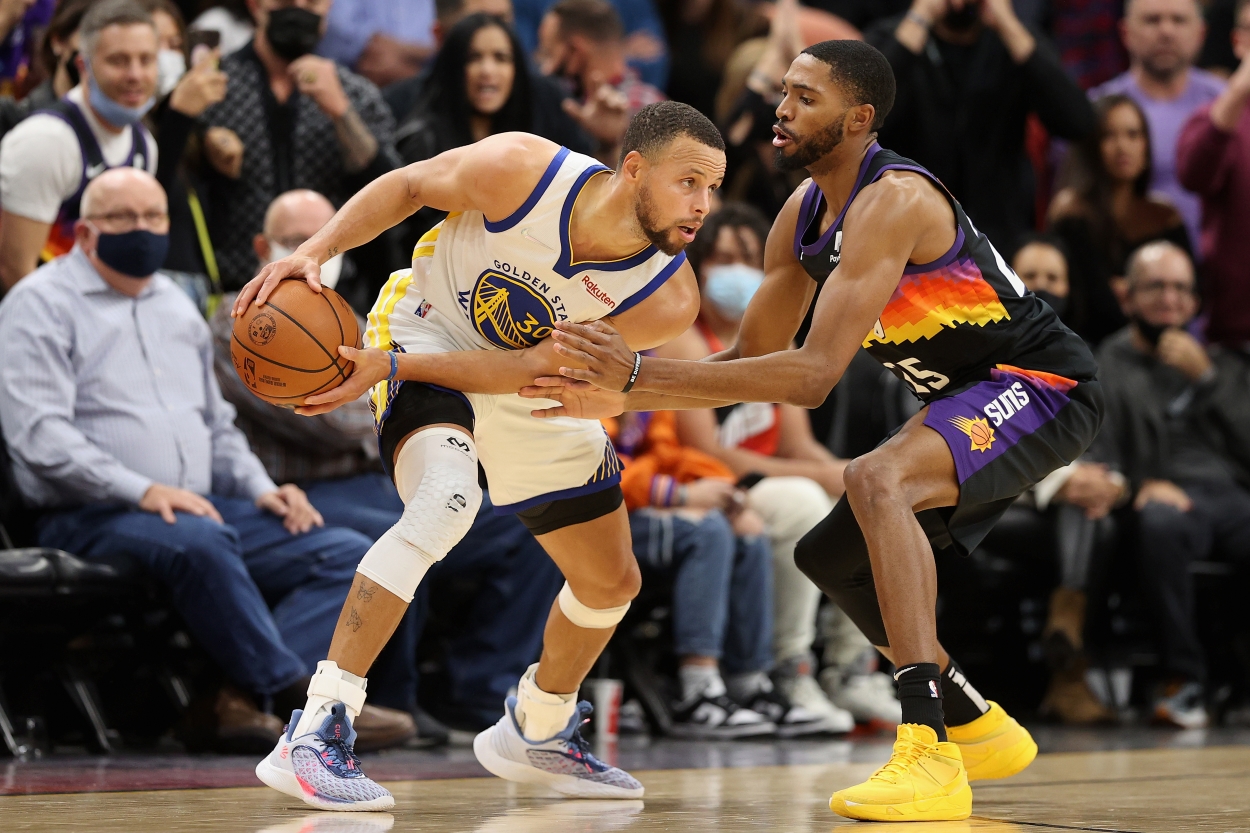 Mikal Bridges of the Phoenix Suns defends Stephen Curry of the Golden State Warriors.