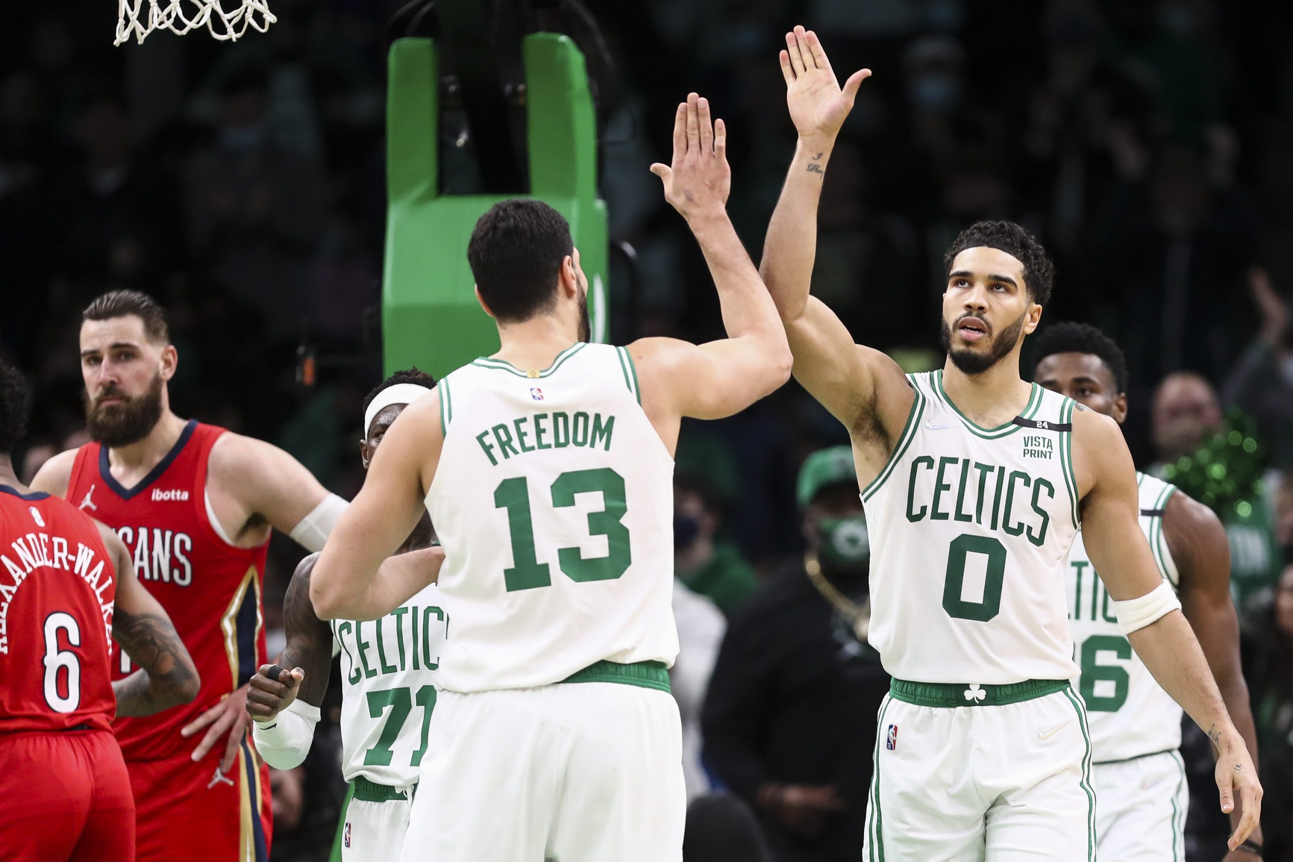 Jayson Tatum #0 reacts with Enes Freedom of the Boston Celtics after scoring a basket.