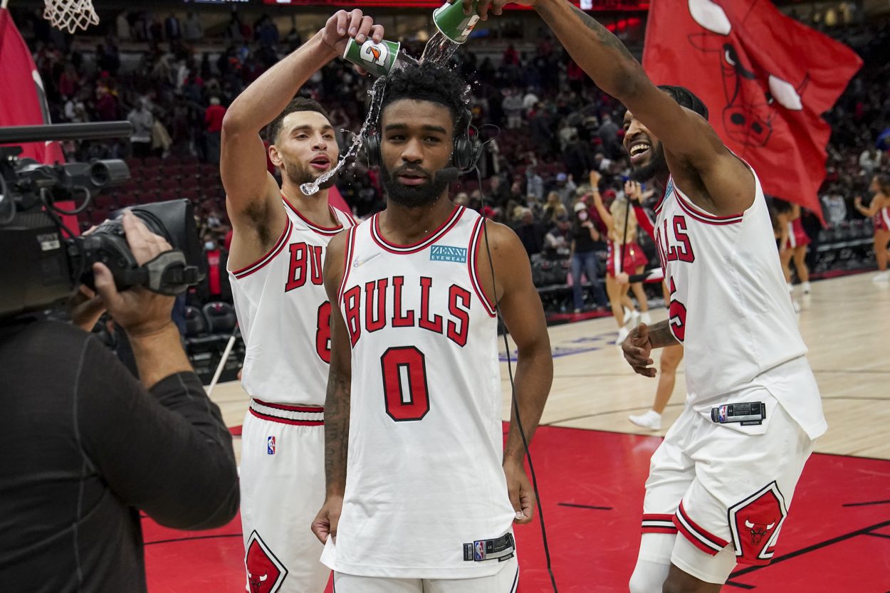 Chicago Bulls star Zach LaVine (L) and forward Derrick Jones Jr. (R) pour water on Coby White during a postgame interview