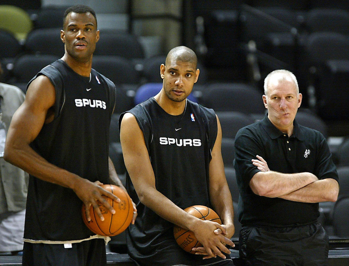 David Robinson, Tim Duncan, and head coach Gregg Popovich of the San Antonio Spurs watch the rest of their team practice for the 2003 NBA Finals | Jeff Haynes/AFP via Getty Images