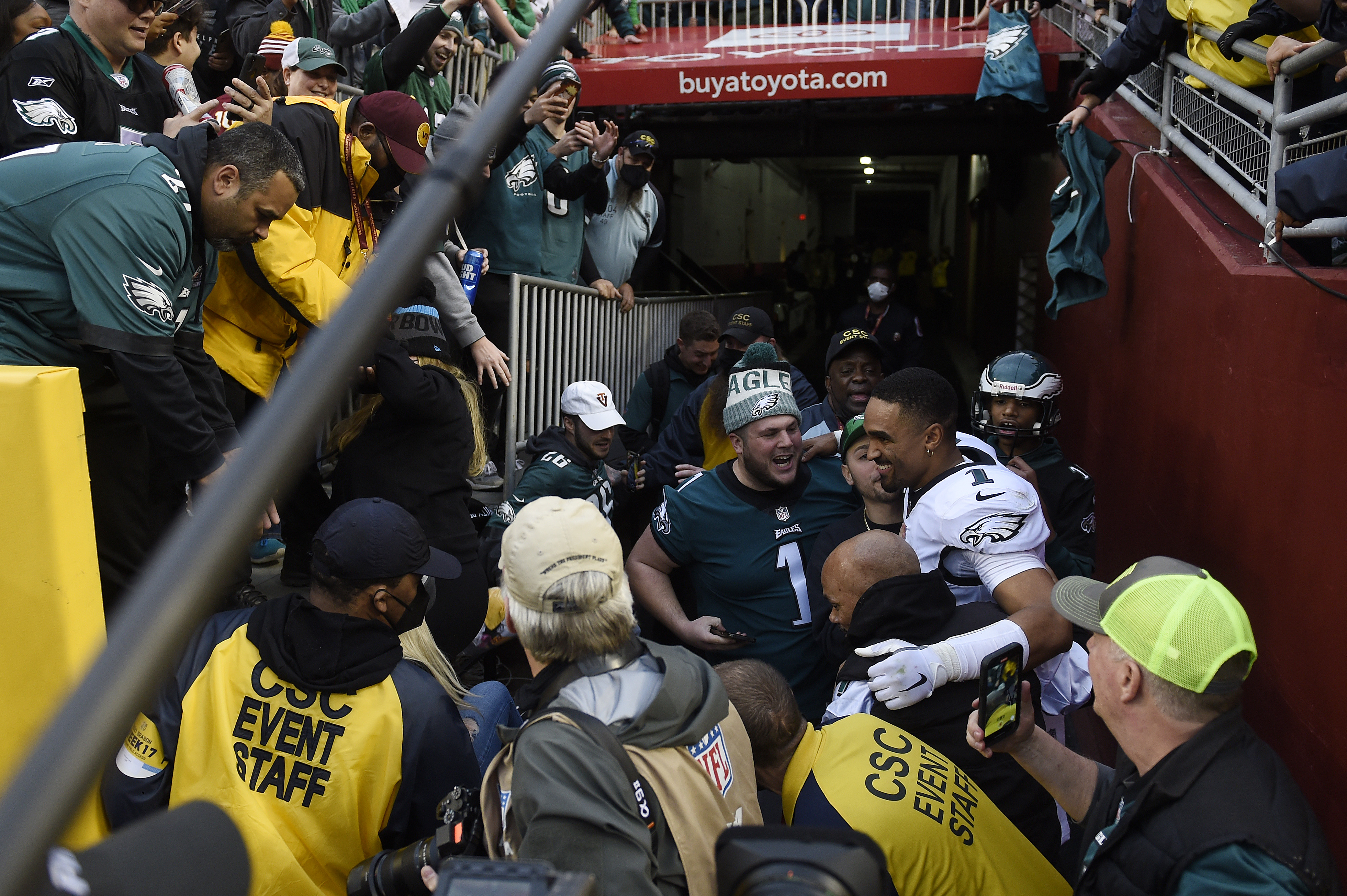 Jalen Hurts poses with Eagles fans after a railing collapsed at FedEx Field