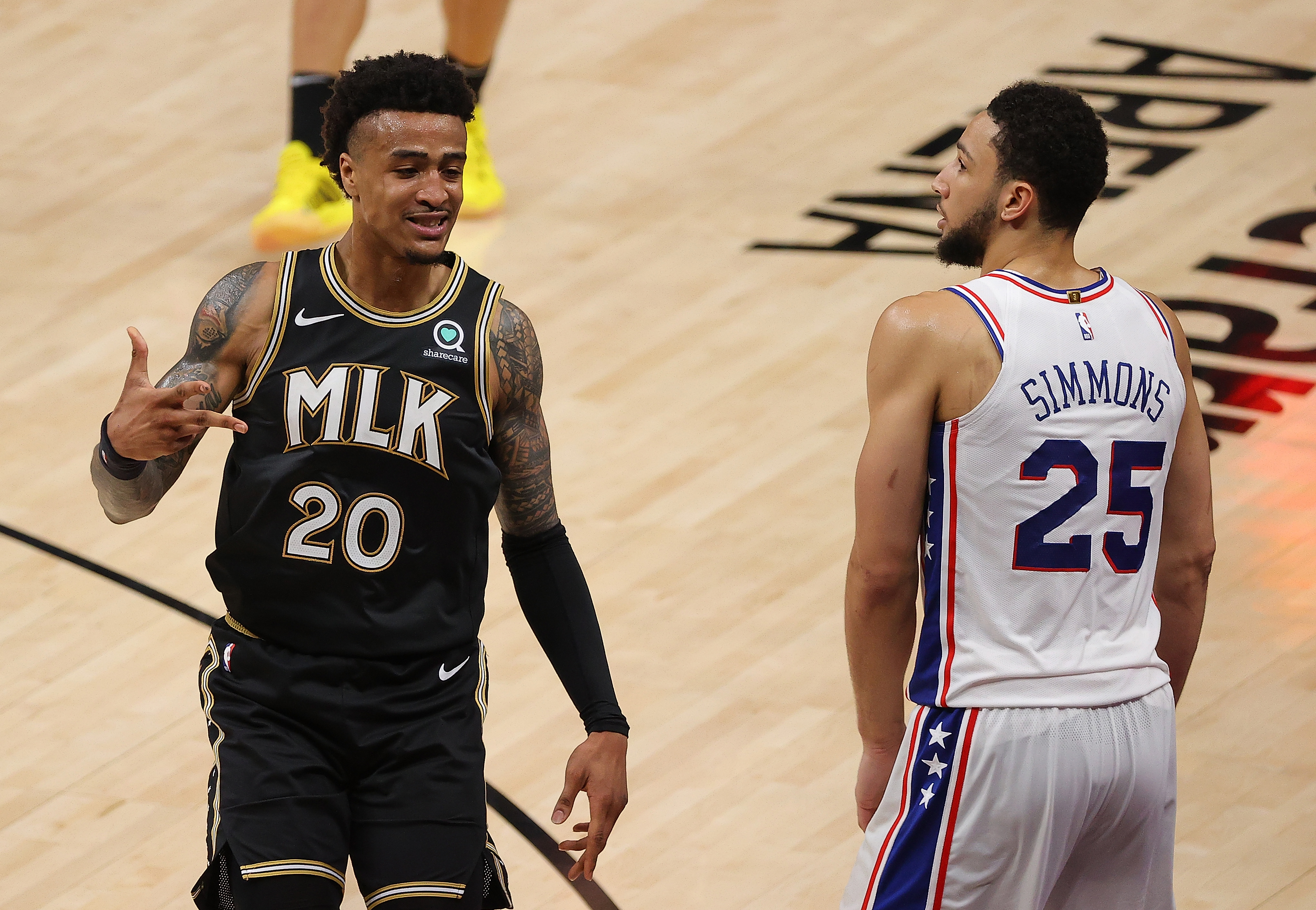Atlanta Hawks forward John Collins celebrates a 3-pointer during the 2021 NBA Playoffs as Philadelphia 76ers guard Ben Simmons looks on