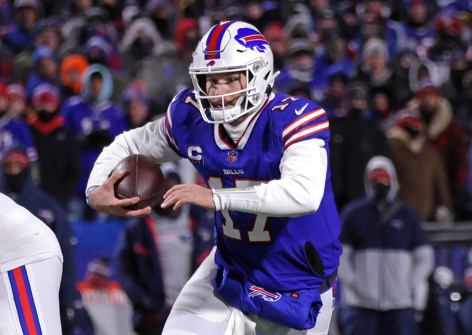 Josh Allen of the Buffalo Bills runs for a first down against the New England Patriots during the first quarter in the AFC Wild Card Game at Highmark Stadium on Jan. 15, 2022, in Orchard Park, New York.