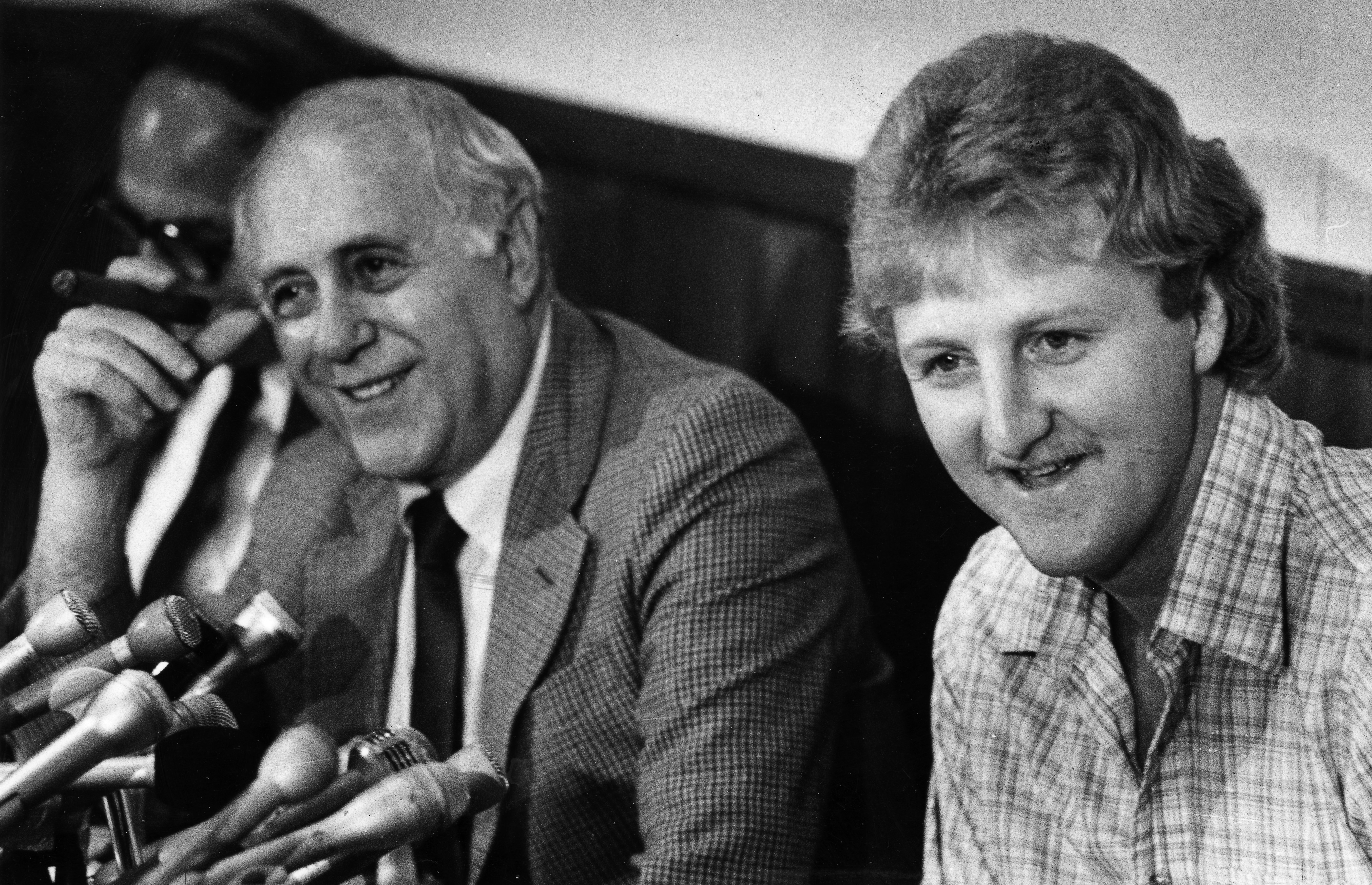 Boston Celtics great Larry Bird (R) answers questions next to Red Auerbach