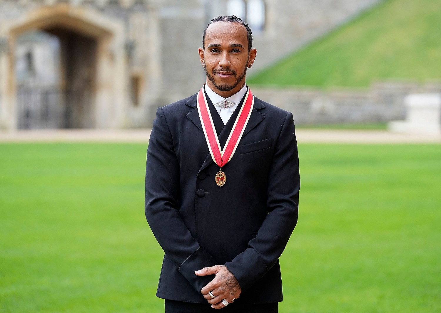 Mercedes' British F1 driver Lewis Hamilton poses with his medal after being appointed as a Knight Bachelor for services to motorsports, by Britain's Prince Charles, Prince of Wales, during an investiture ceremony at Windsor Castle on Dec. 15, 2021.