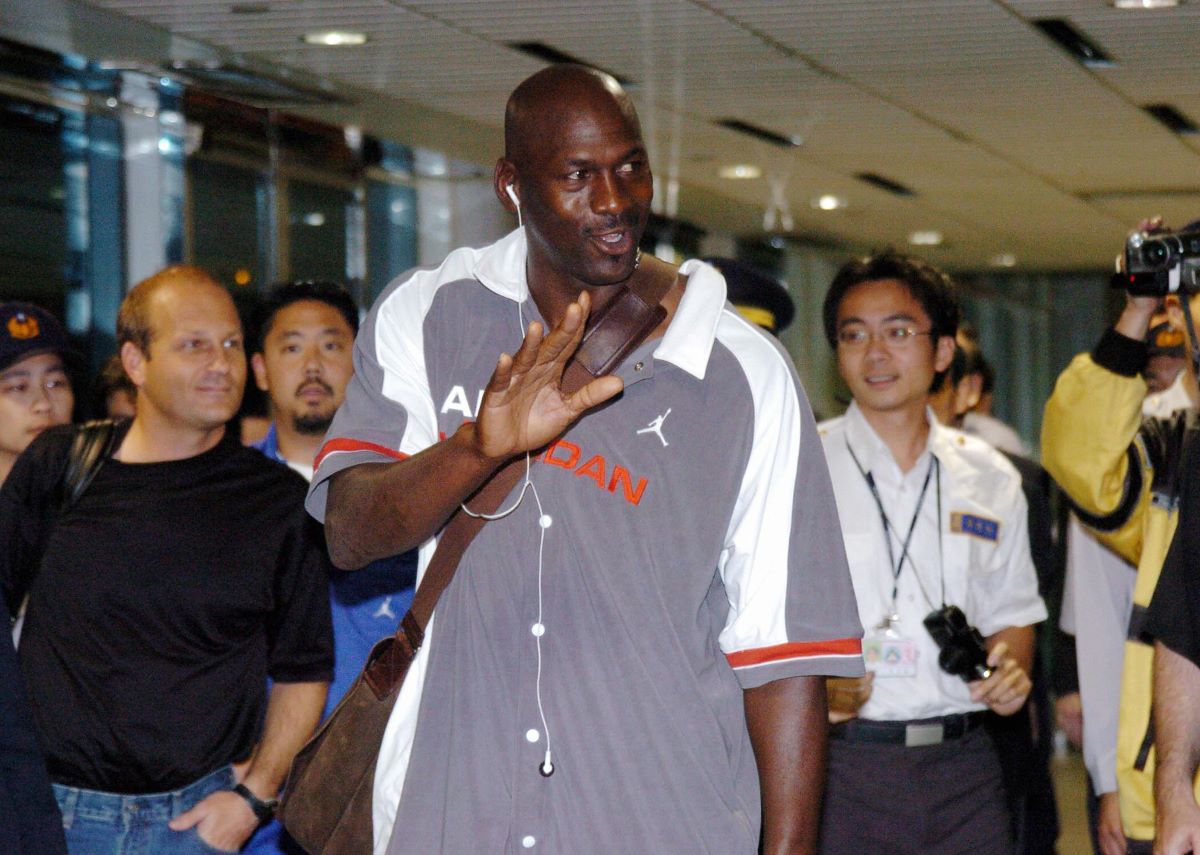 Michael Jordan walks through an airport in 2004 and waves at fans