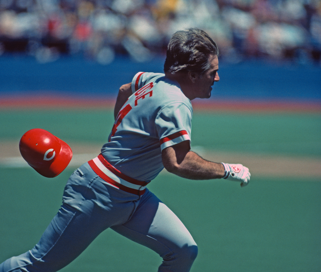 Pete Rose of the Cincinnati Reds loses his helmet as he runs to first base.