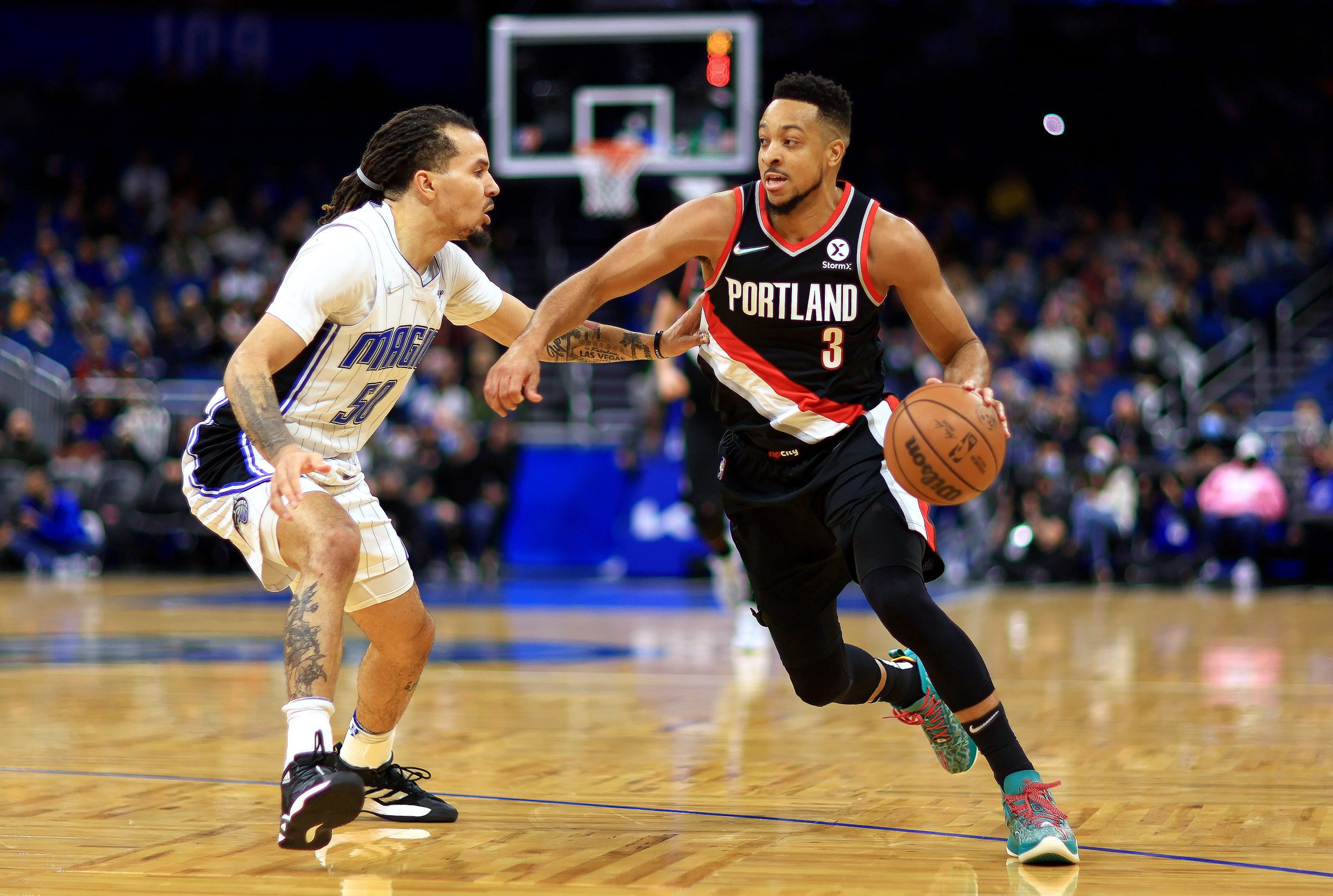 Portland Trail Blazers star guard CJ McCollum drives past Orlando Magic guard Cole Anthony on Monday night at Amway Center.