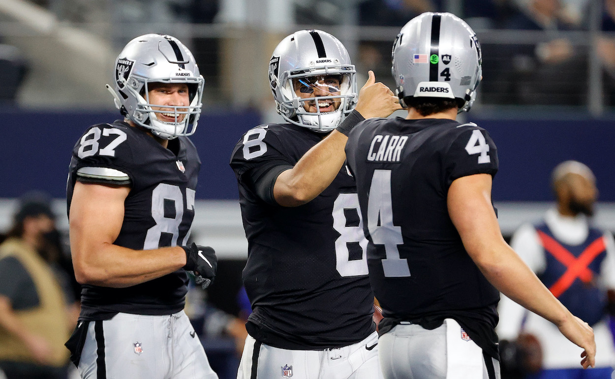 Marcus Mariota of the Las Vegas Raiders celebrates scoring his sides fourth touchdown with Derek Carr during the third quarter of the NFL game between Las Vegas Raiders and Dallas Cowboys at AT&T Stadium on November 25, 2021 in Arlington, Texas. The Raiders clinch a playoff spot with a win in Week 18 vs. the LA Chargers.