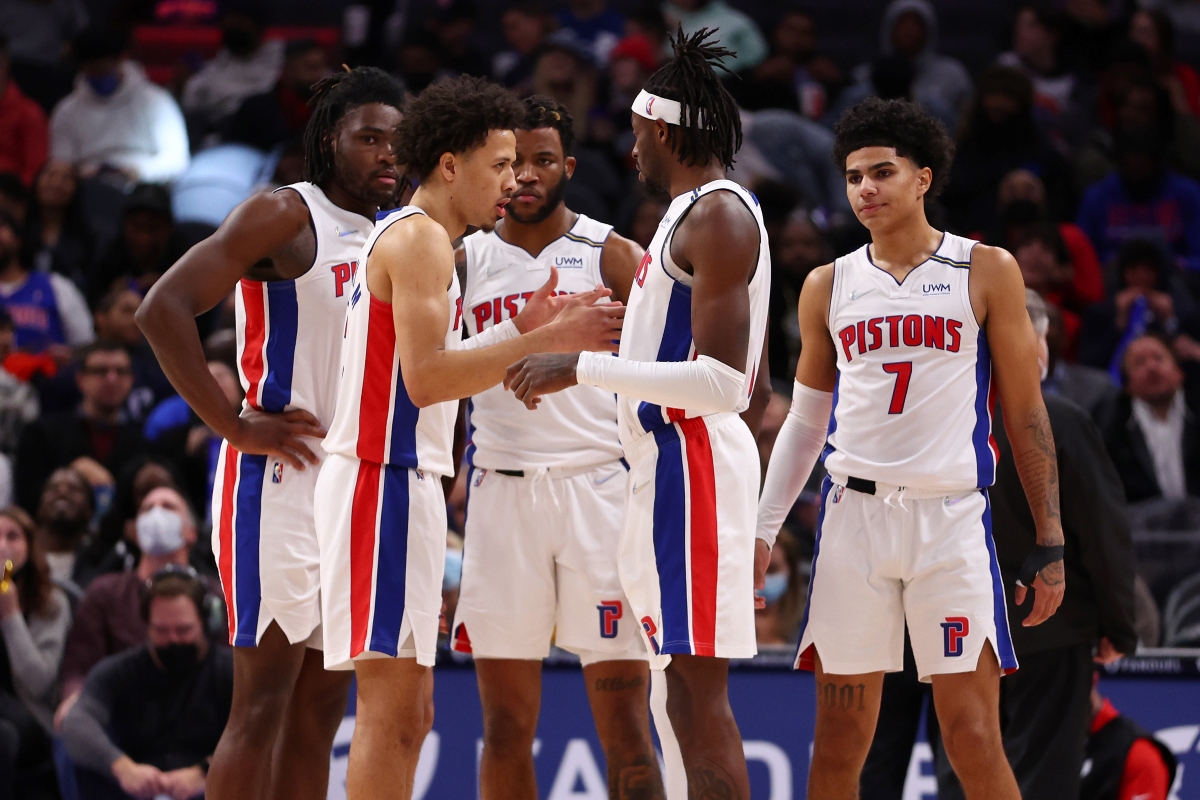 Detroit Pistons guard Cade Cunningham talks with his teammates, including Jerami Grant, during a game.