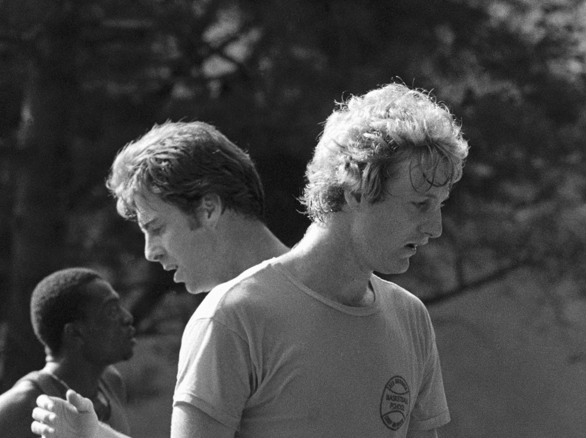 Boston Celtics' star rookie Larry Bird of Indiana State and veteran center Dave Cowens go over some plays during training camp in 1979.