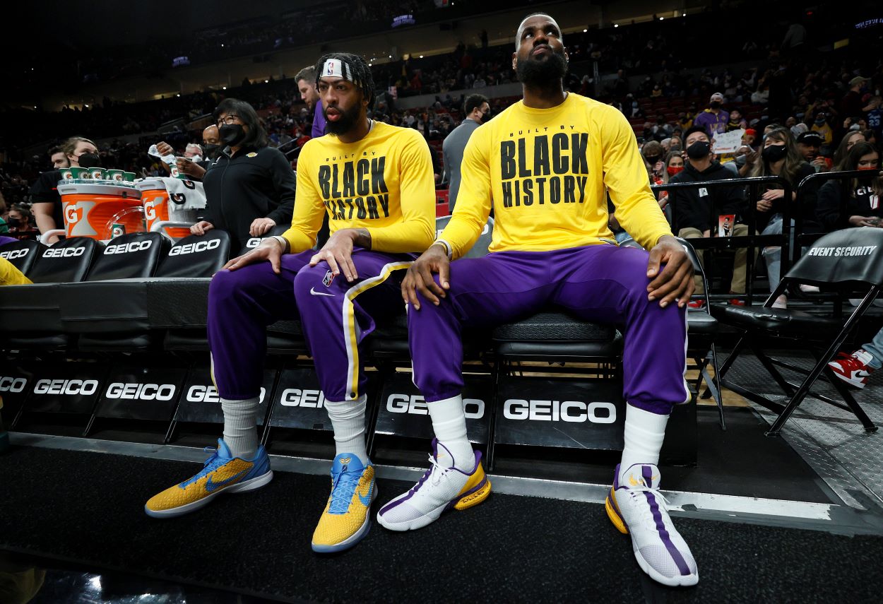 Lakers forward LeBron James and Anthony Davis sit on the bench before an NBA game.