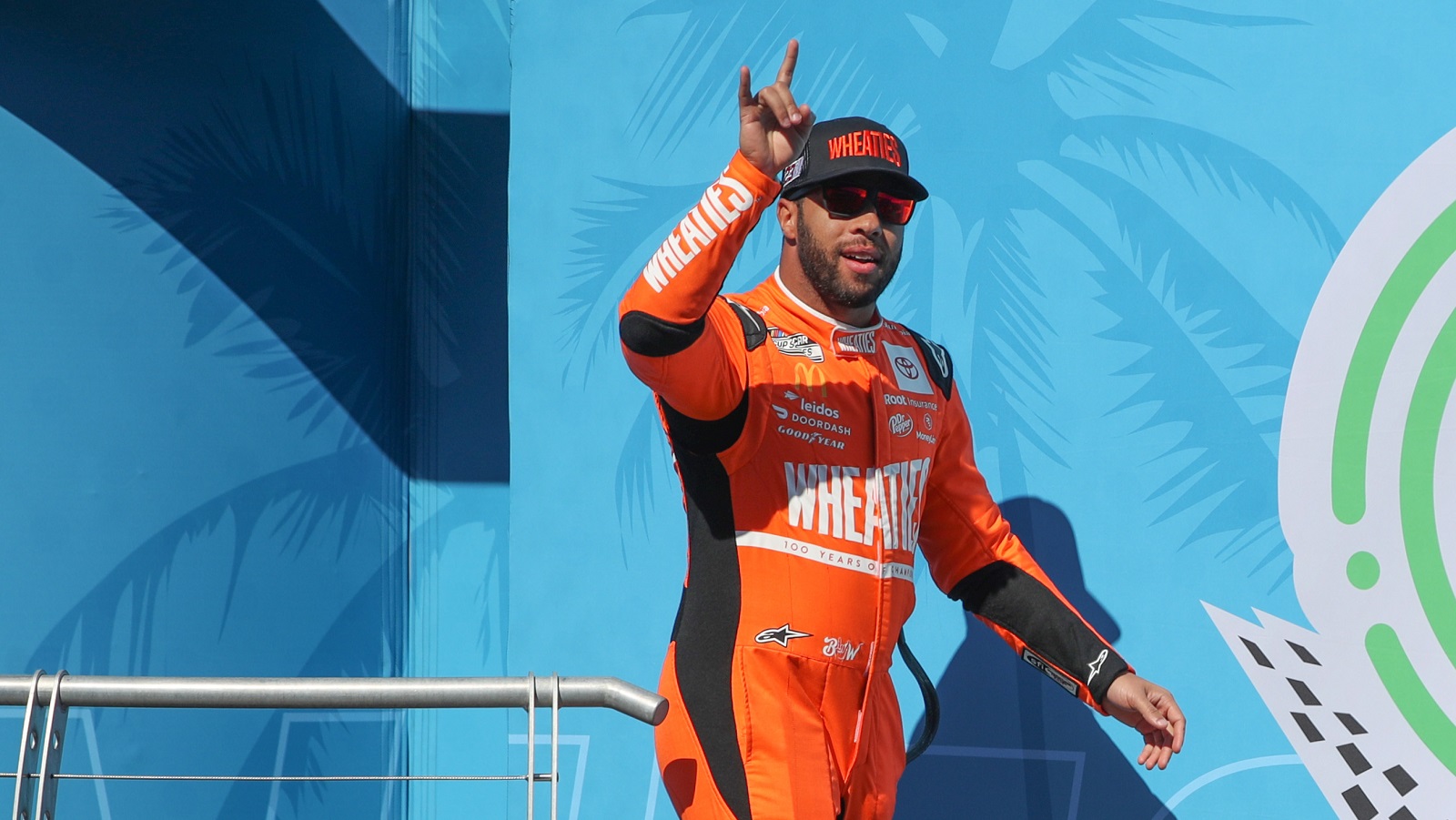 Bubba Wallace waves to fans as he walks onstage during driver intros for the NASCAR Cup Series Wise Power 400 at Auto Club Speedway on Feb. 27, 2022 in Fontana, California. | Meg Oliphant/Getty Images
