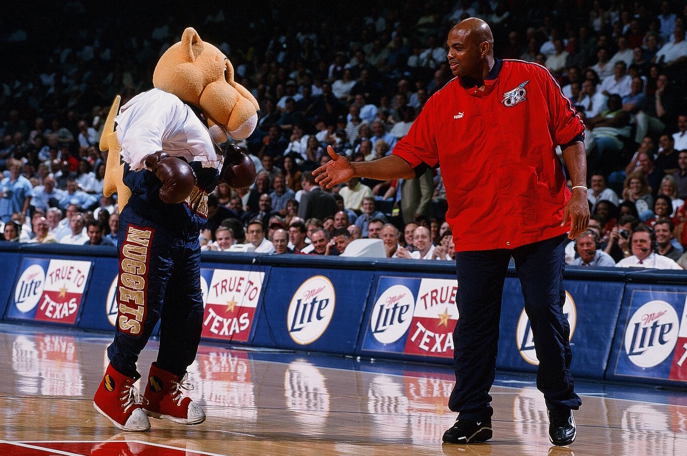 Charles Barkley of the Houston Rockets greets the Denver Nuggets mascot, Rocky, during the game against the Vancouver Grizzlies on April 19, 2000.