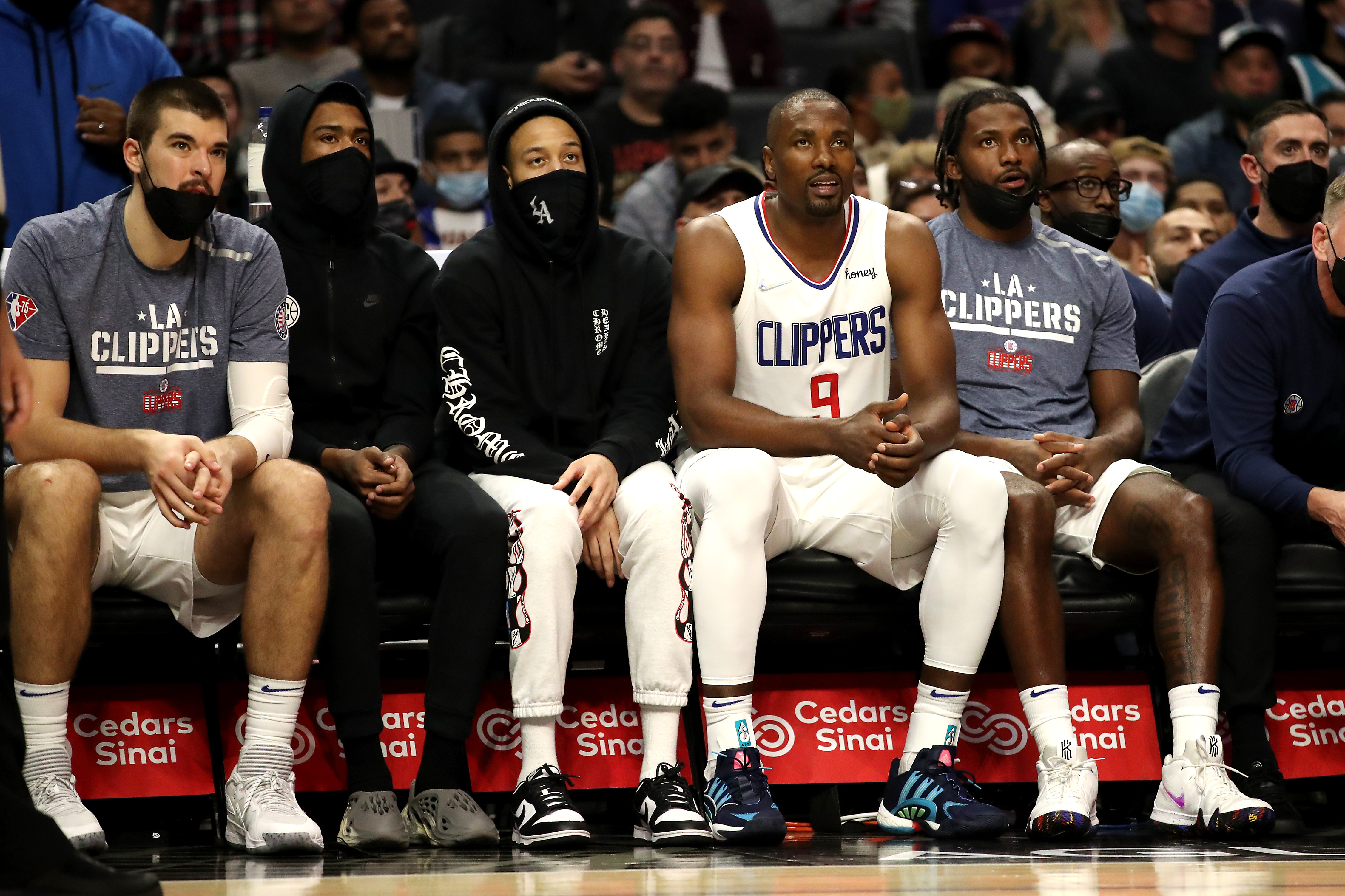 Members of the Los Angeles Clippers sit on the bench during an NBA game against the Charlotte Hornets in November 2021